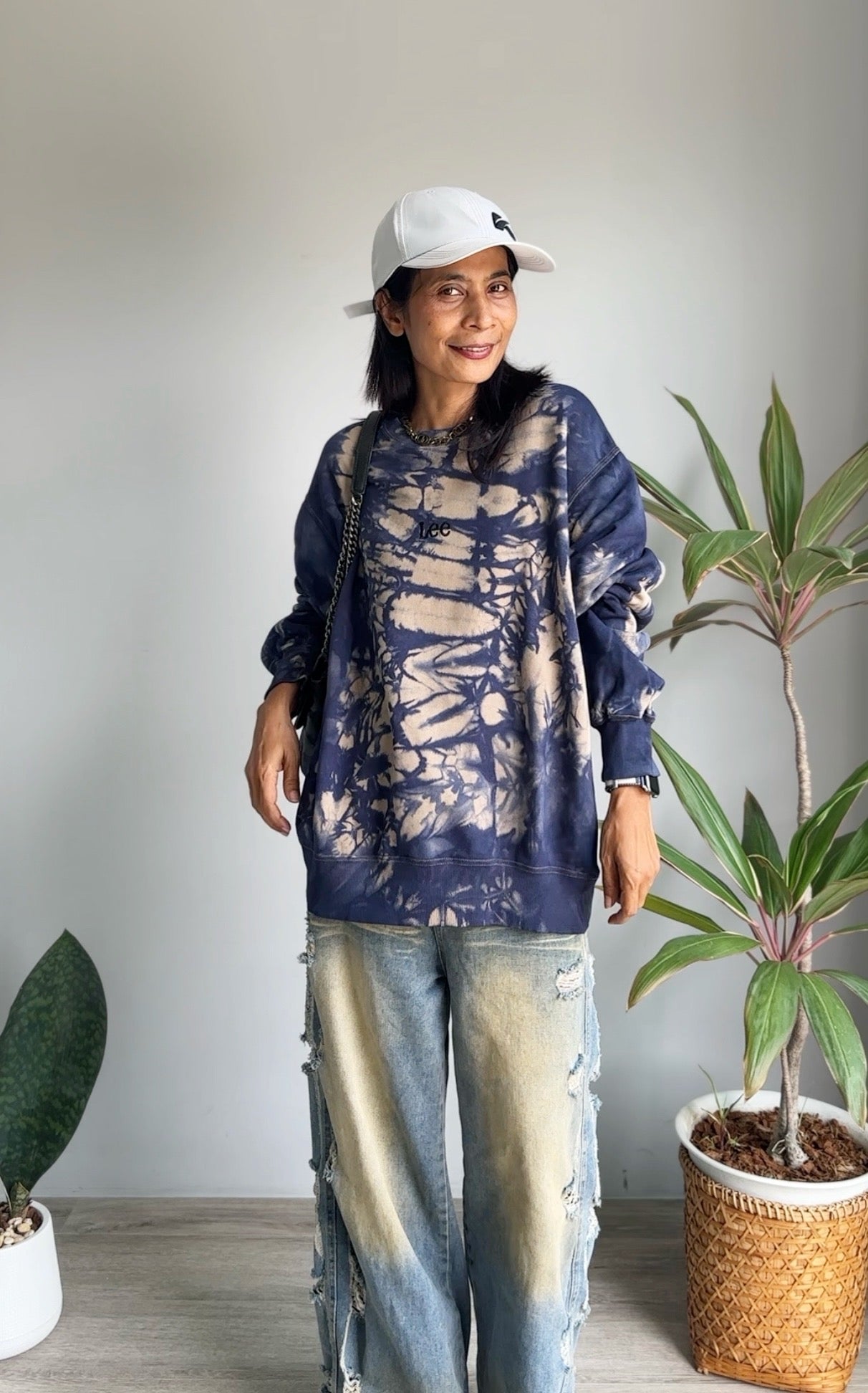 Model wearing vintage Lee shibori tie dye sweatshirt with ripped jeans