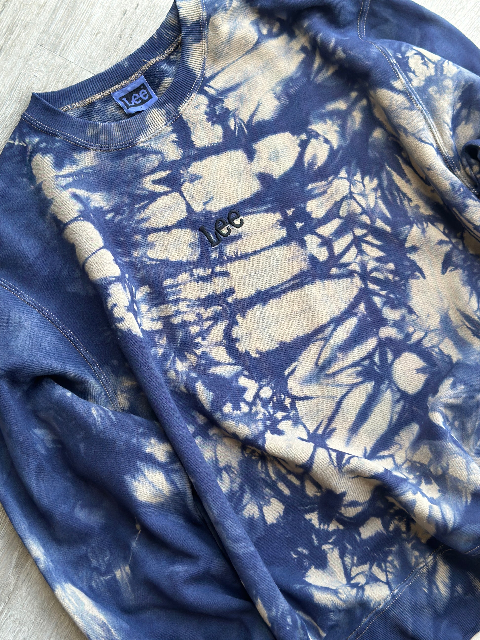 Blue and white tie-dye sweatshirt on a flat surface