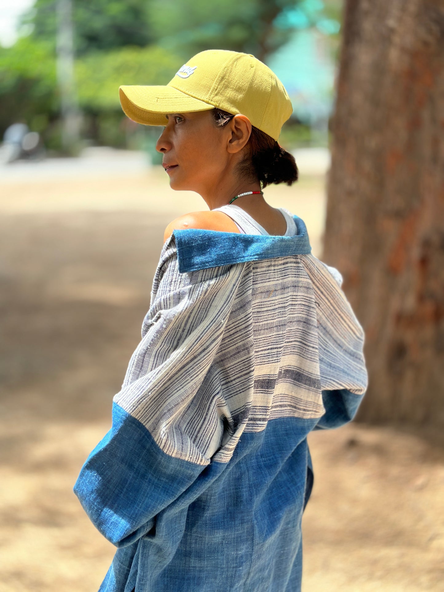 Back view of a Woman wearing natural indigo hill tribe open front cardigan outdoors at the beach, Nuichan