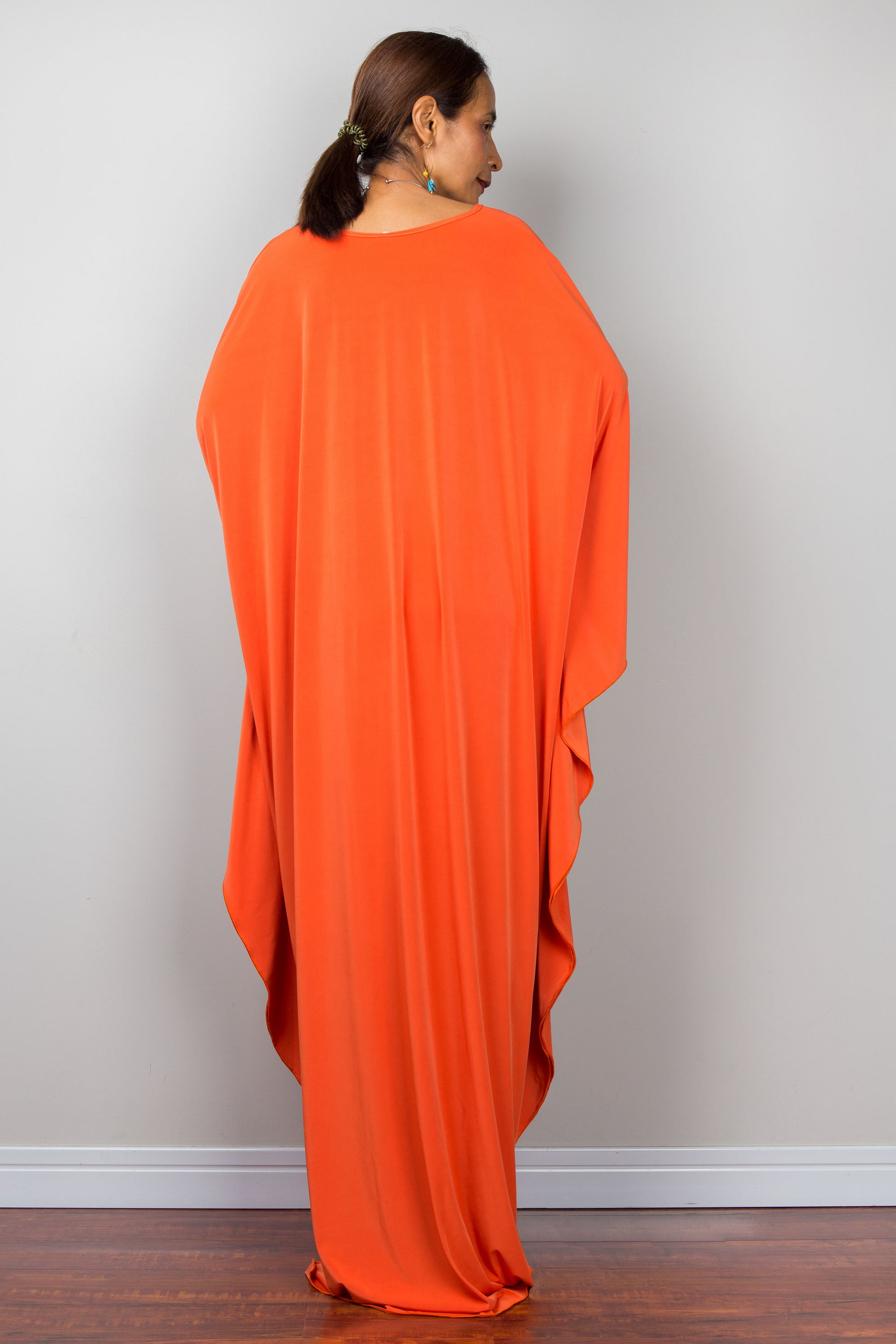 Orange kaftan dress with batwing sleeves and plunging v neckline. Back view