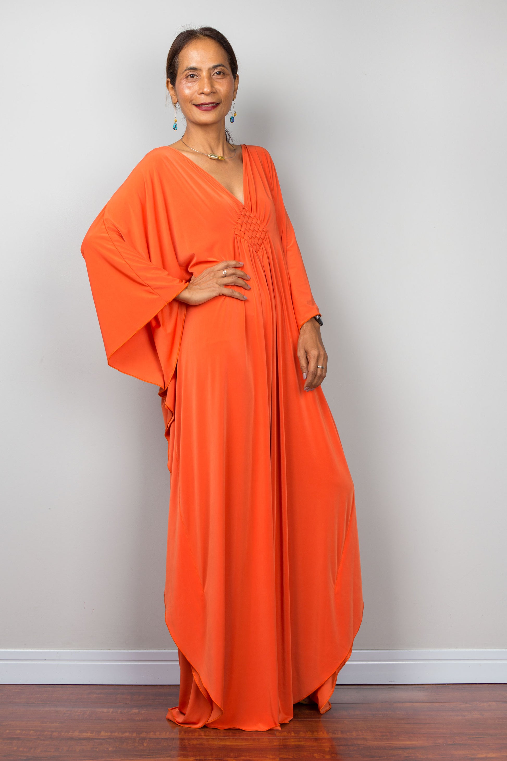 Long Orange caftan dress with batwing sleeves and plunging v neckline. 