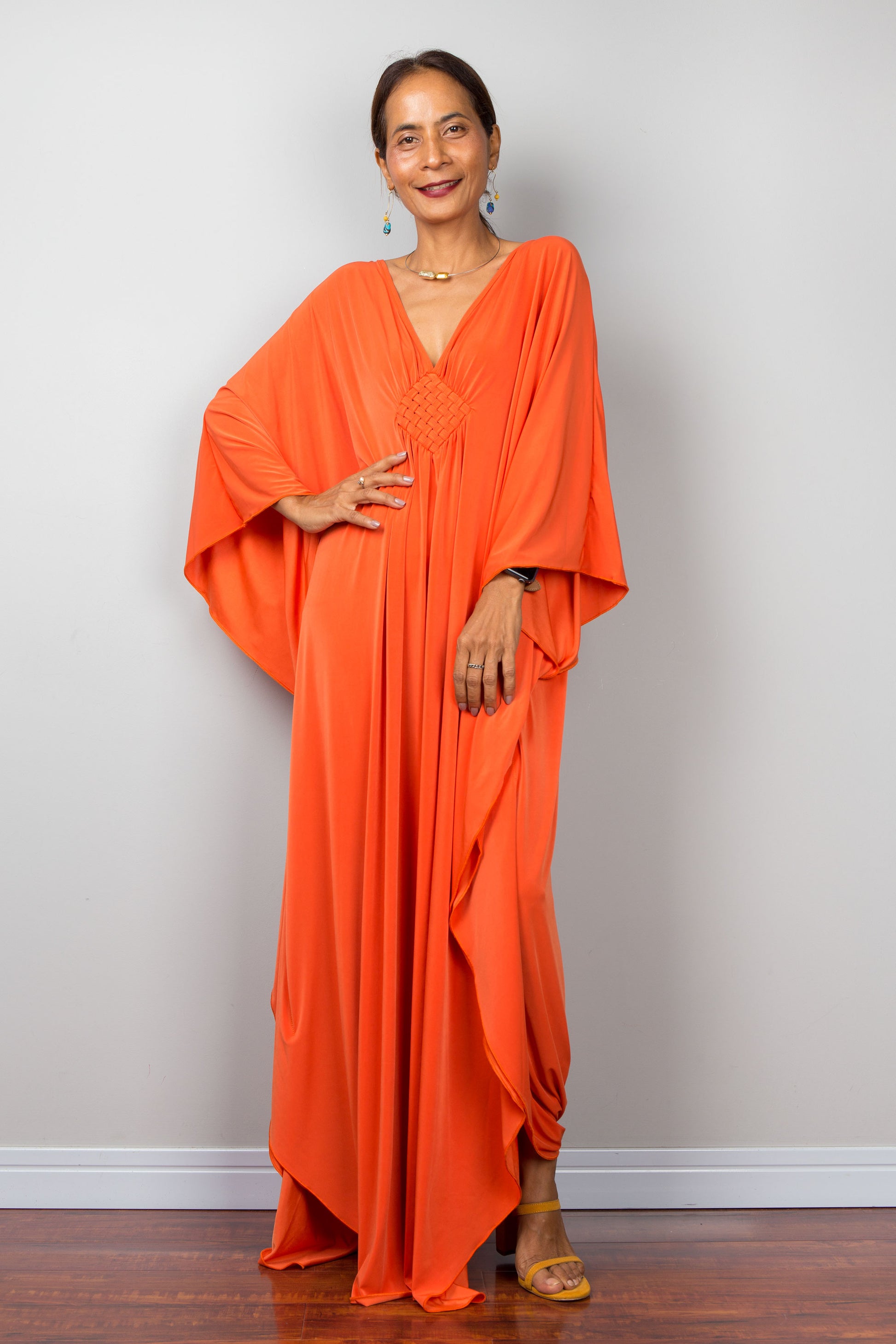 Orange kaftan dress with batwing sleeves and plunging v neckline. Front view.