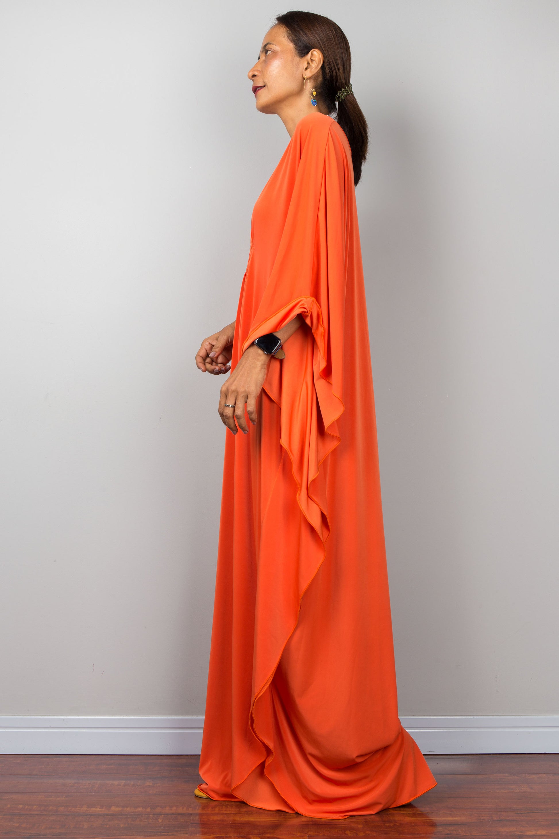 Orange kaftan dress with batwing sleeves and plunging v neckline. Side view