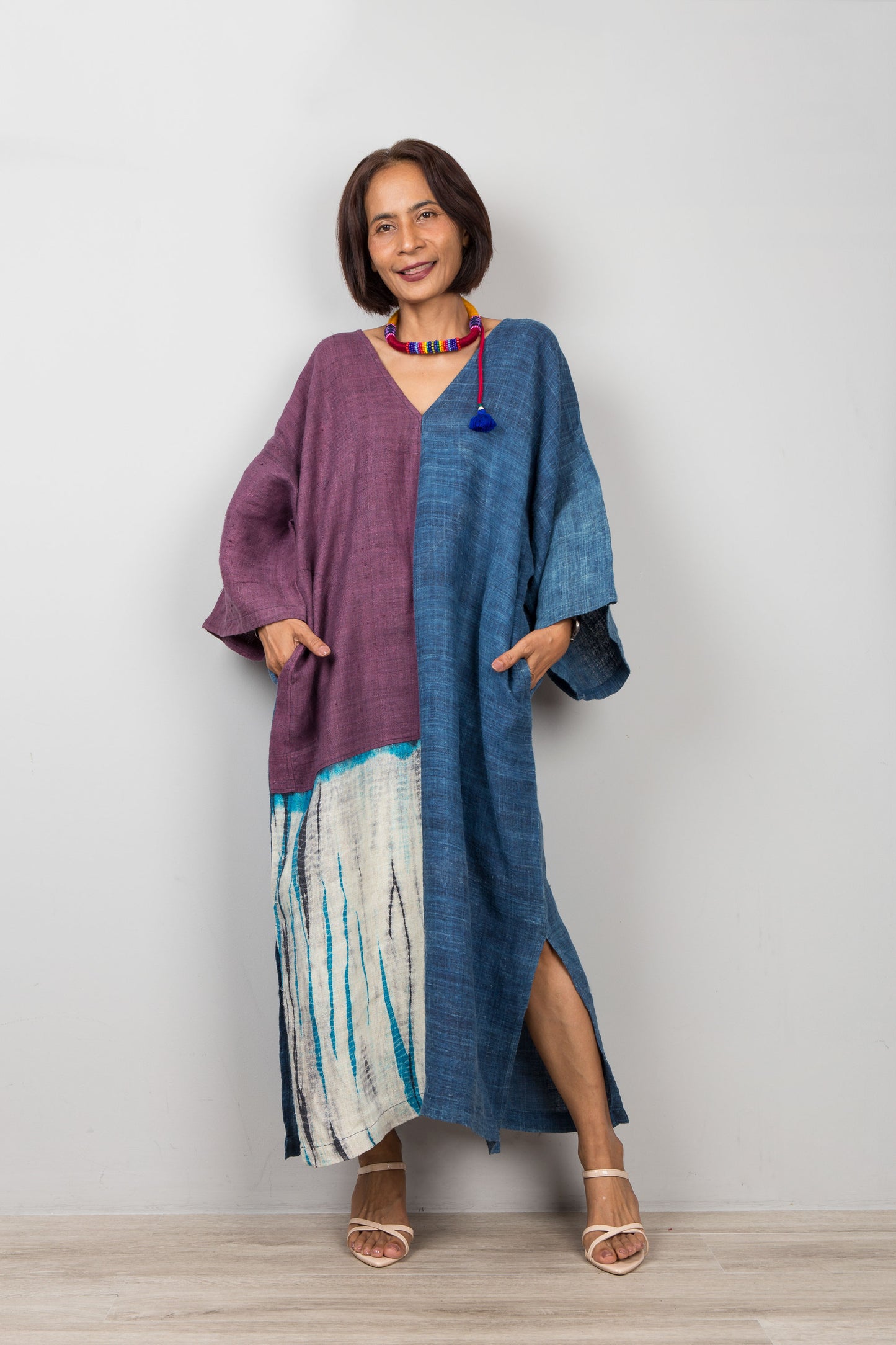 Model wearing indigo hemp caftan dress with pockets, styled with heeled sandals