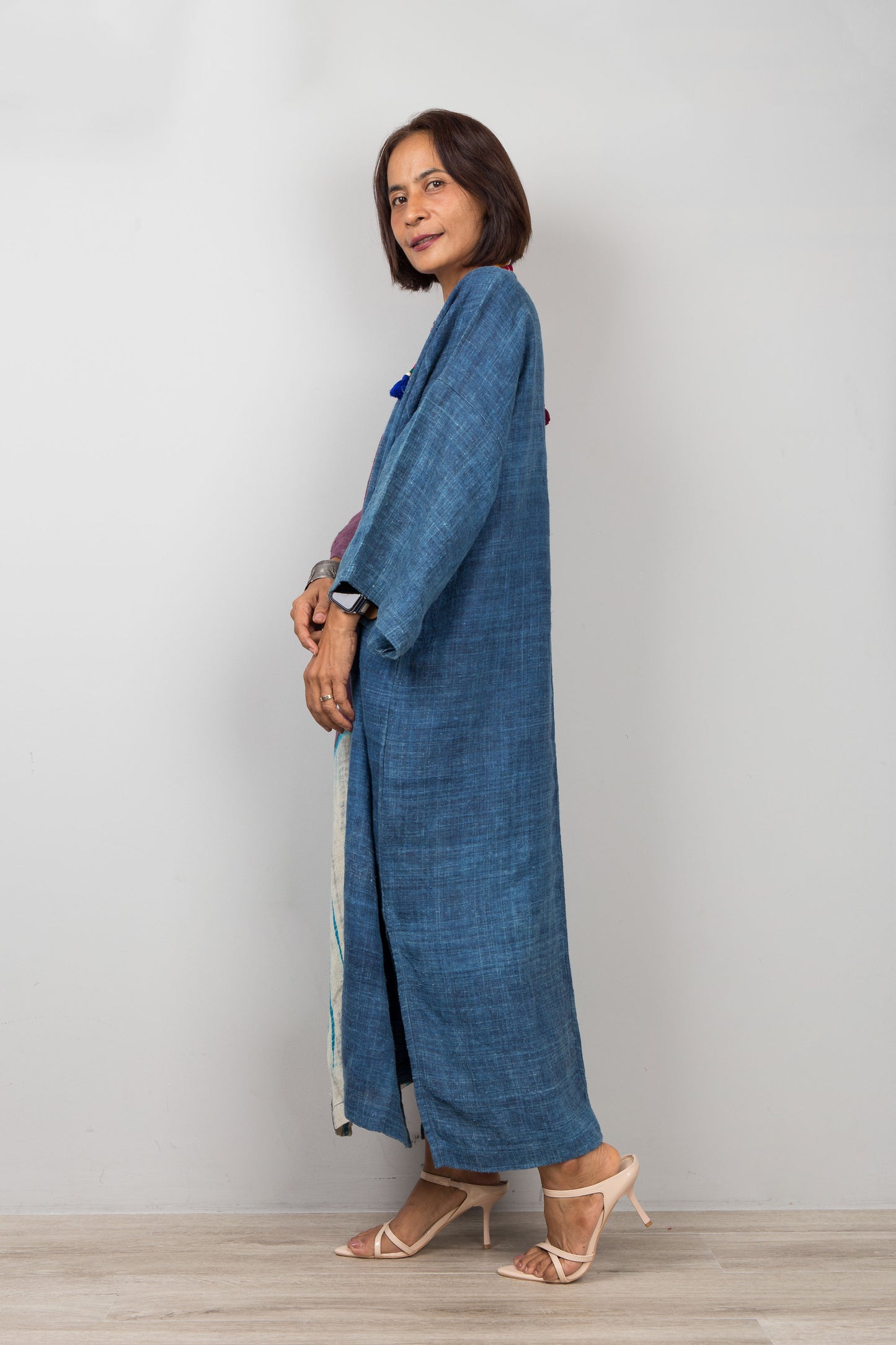 Model wearing indigo hemp caftan dress with pockets, shibori tie dye detail, styled with heeled sandals