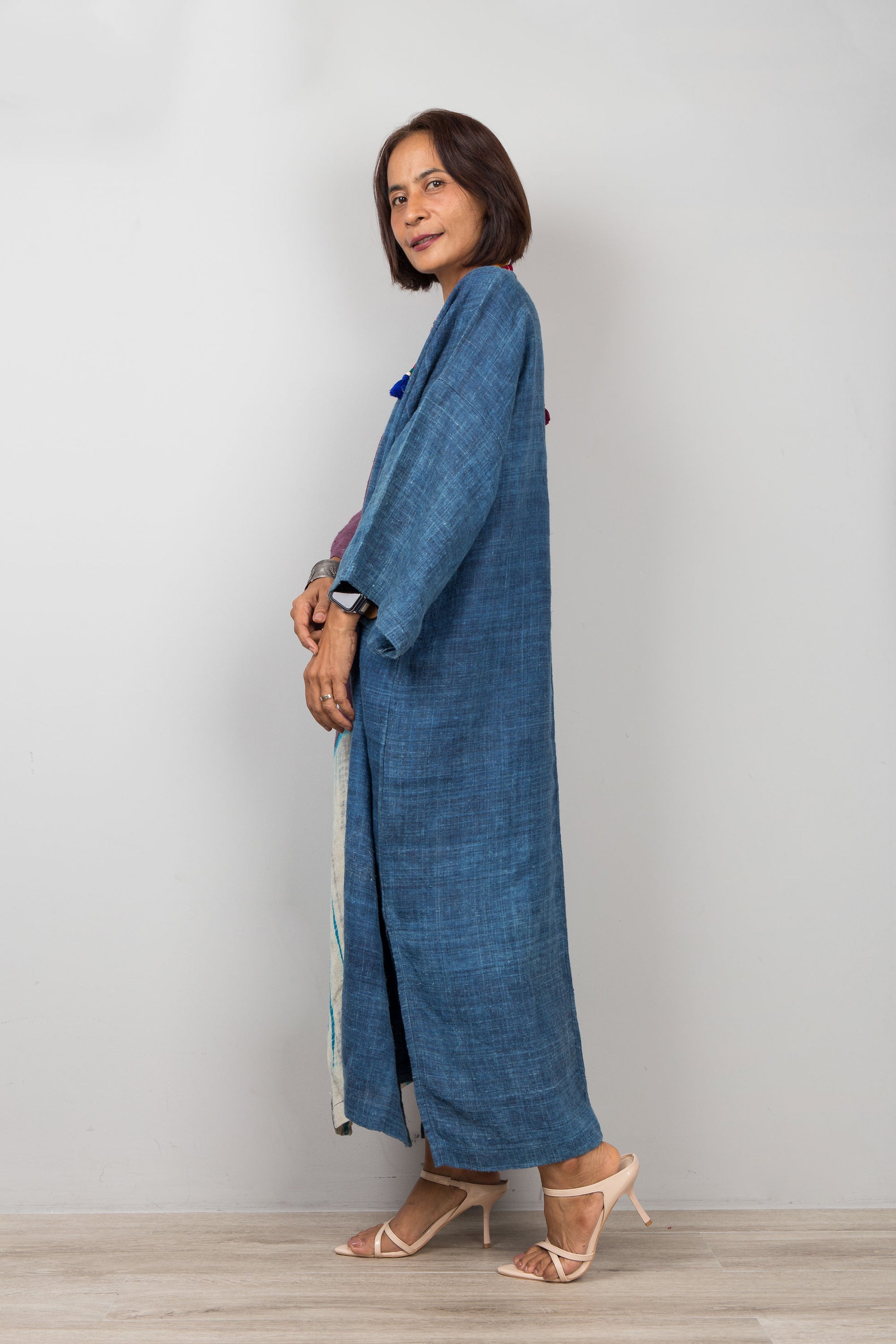 Model wearing indigo hemp caftan dress with pockets, shibori tie dye detail, styled with heeled sandals