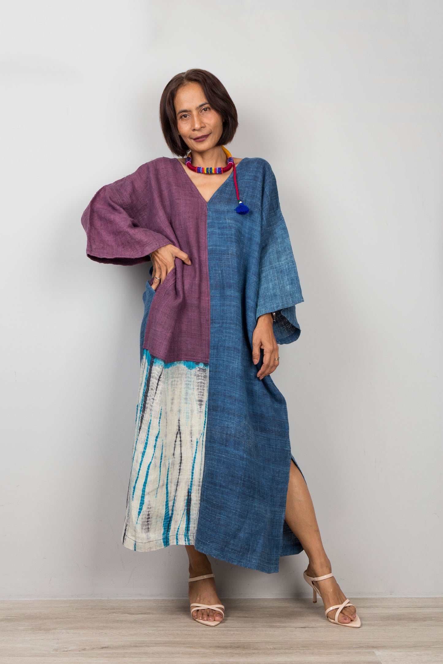 Woman wearing a two-tone dress with a purple and blue on a plain background