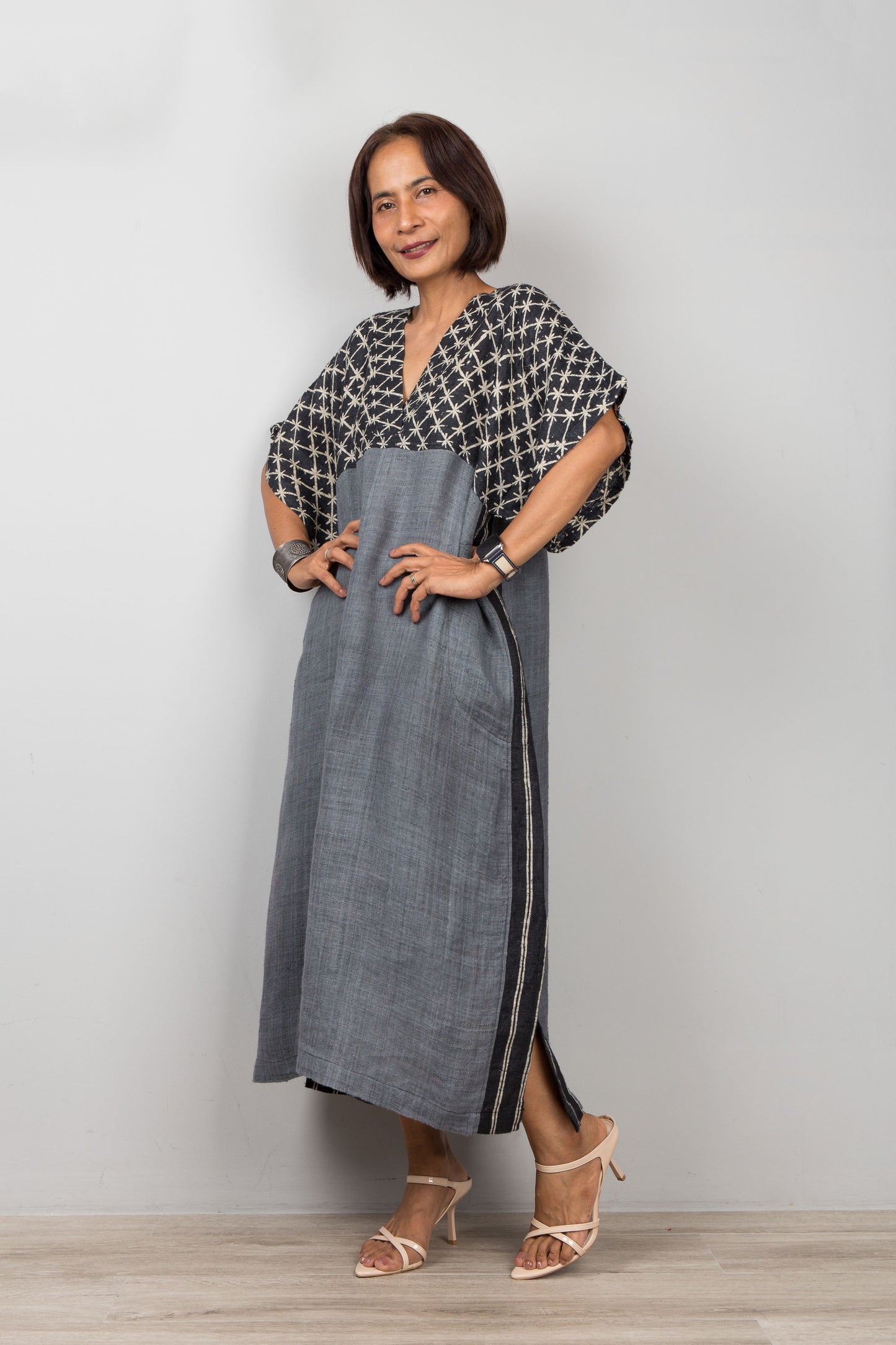 Woman wearing a gray caftan dress for petite, against a plain background