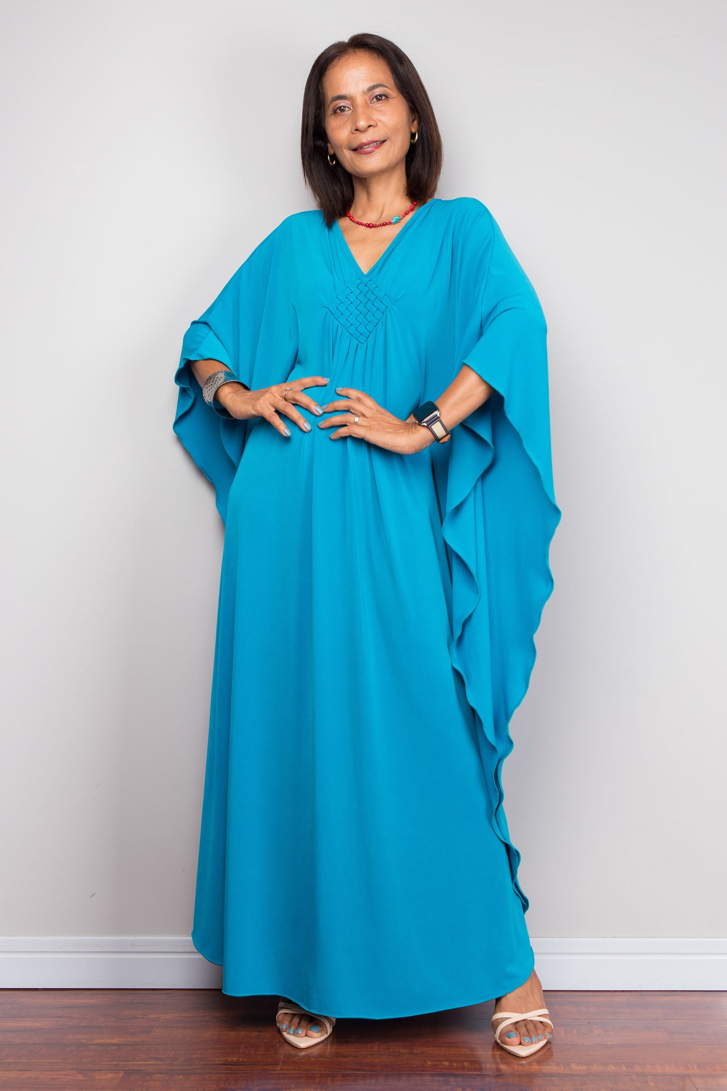 Petite Woman wearing a blue kaftan with a plain white background