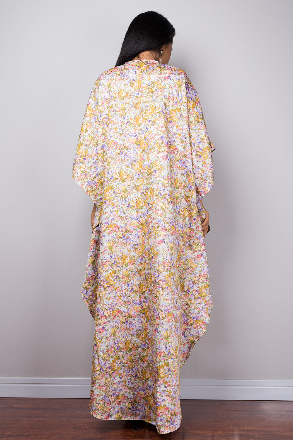 Woman wearing a petite floral dress with a neutral background