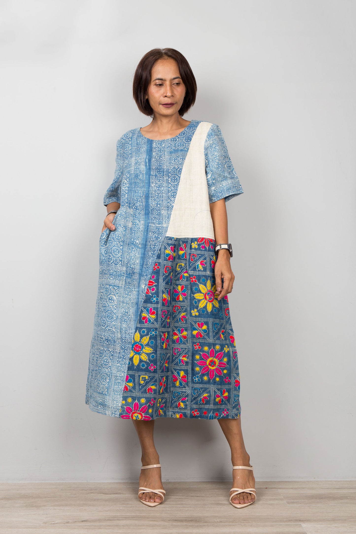 Nuichan wearing a blue petite caftan with floral embroidery against a plain background