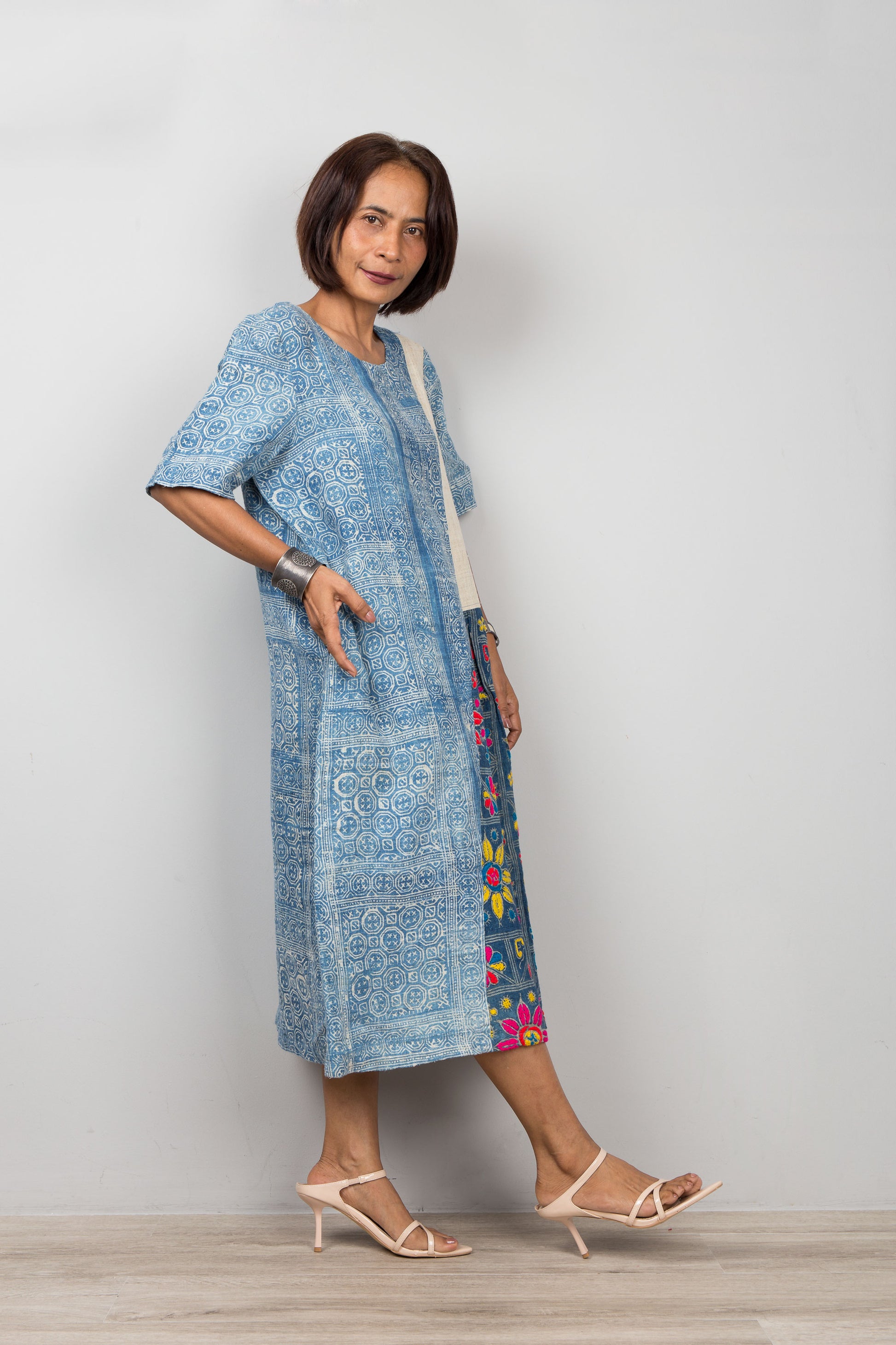 Nuichan wearing a blue batik caftan for petite with floral embroidery against a plain background