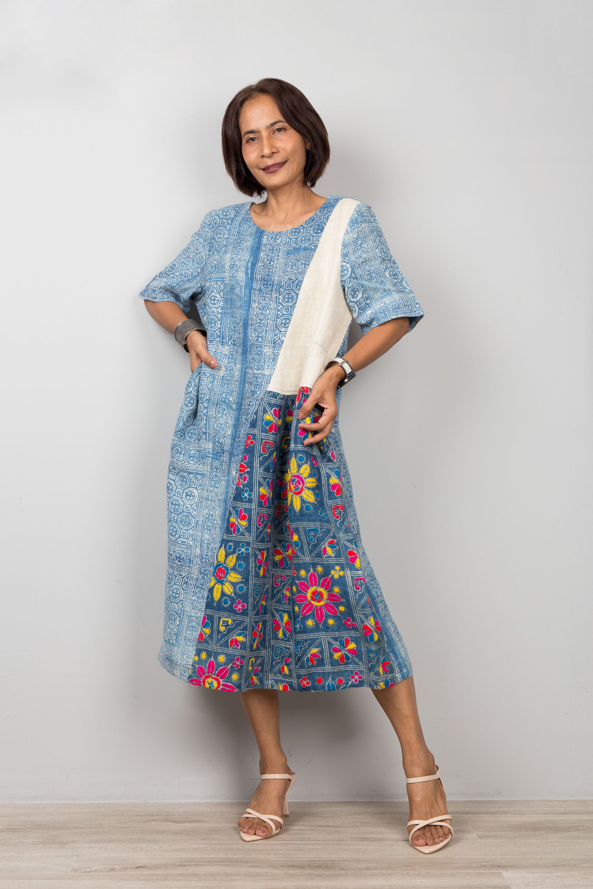 Nuichan wearing a blue batik petite kaftan dress with floral embroidery against a plain background