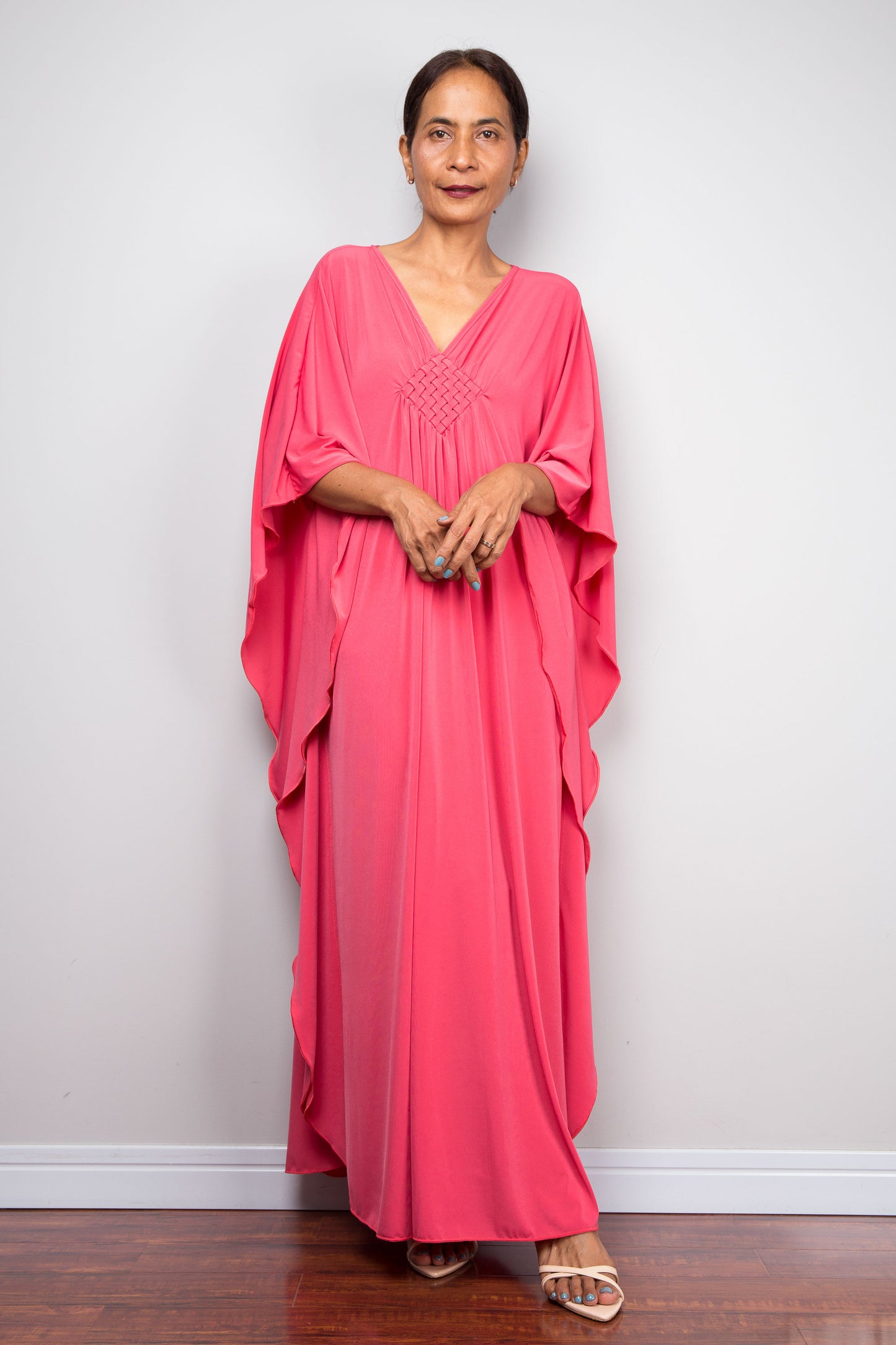 Petite Woman wearing a pink caftan dress against a plain background