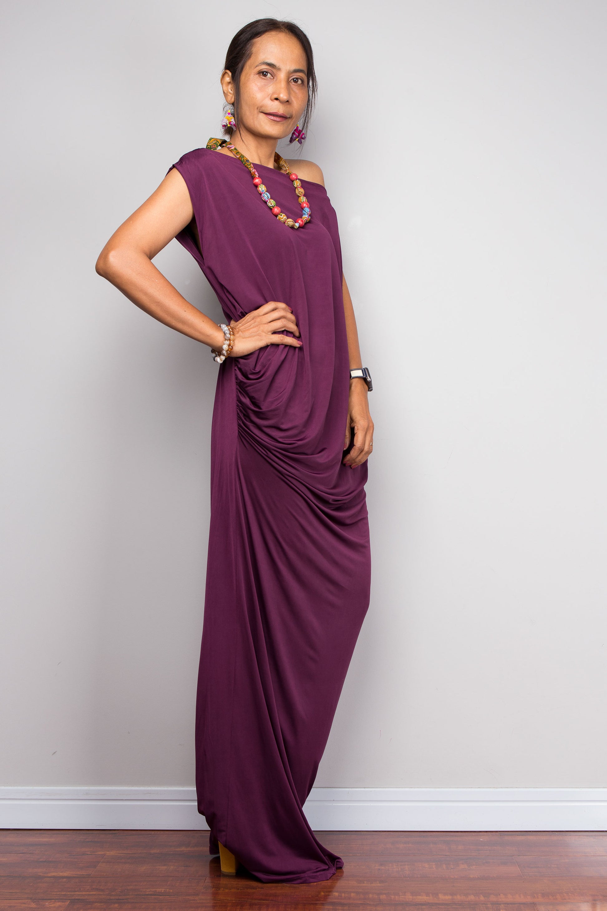 Woman wearing a purple dress against a plain background