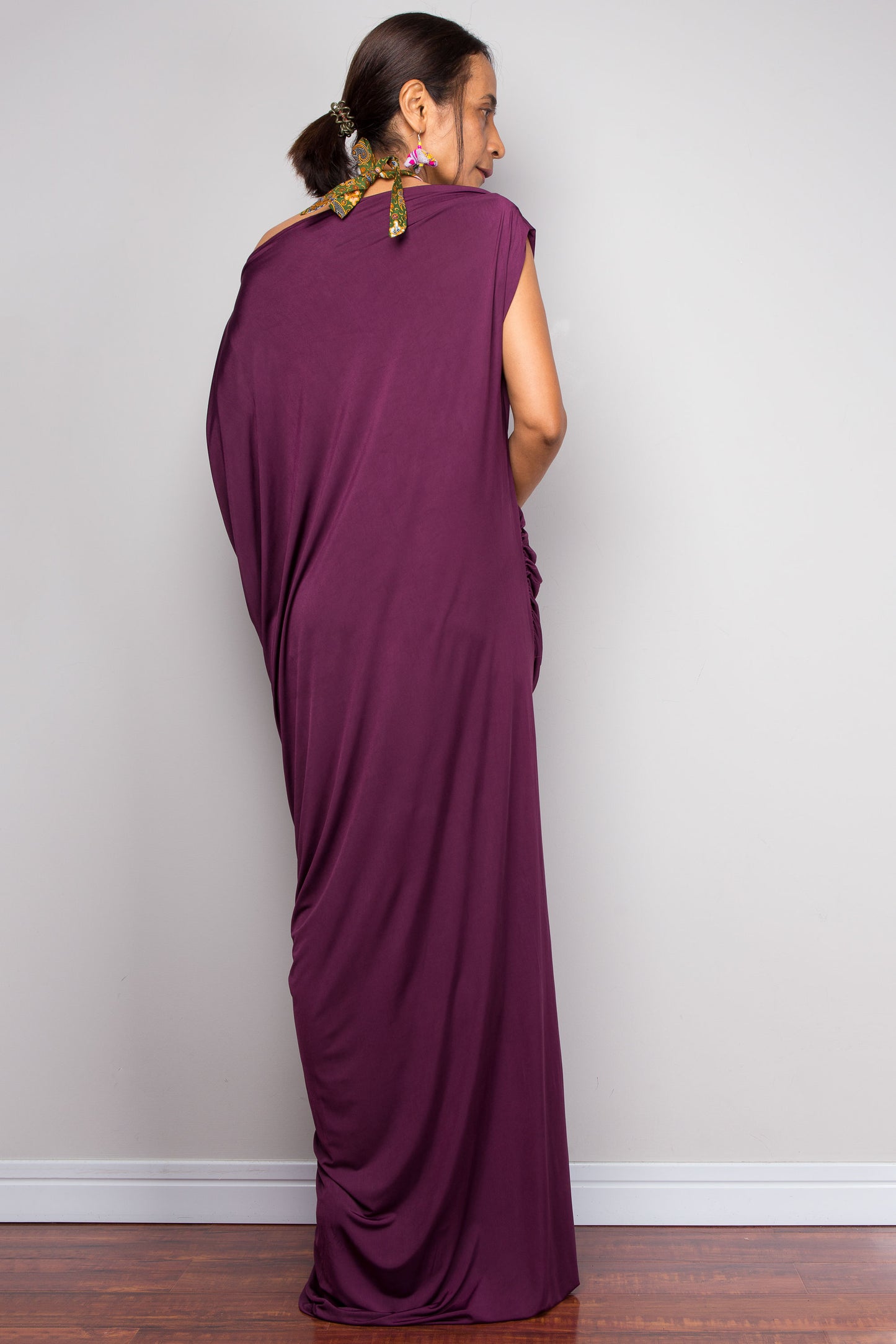 Woman wearing a long purple dress against a plain background