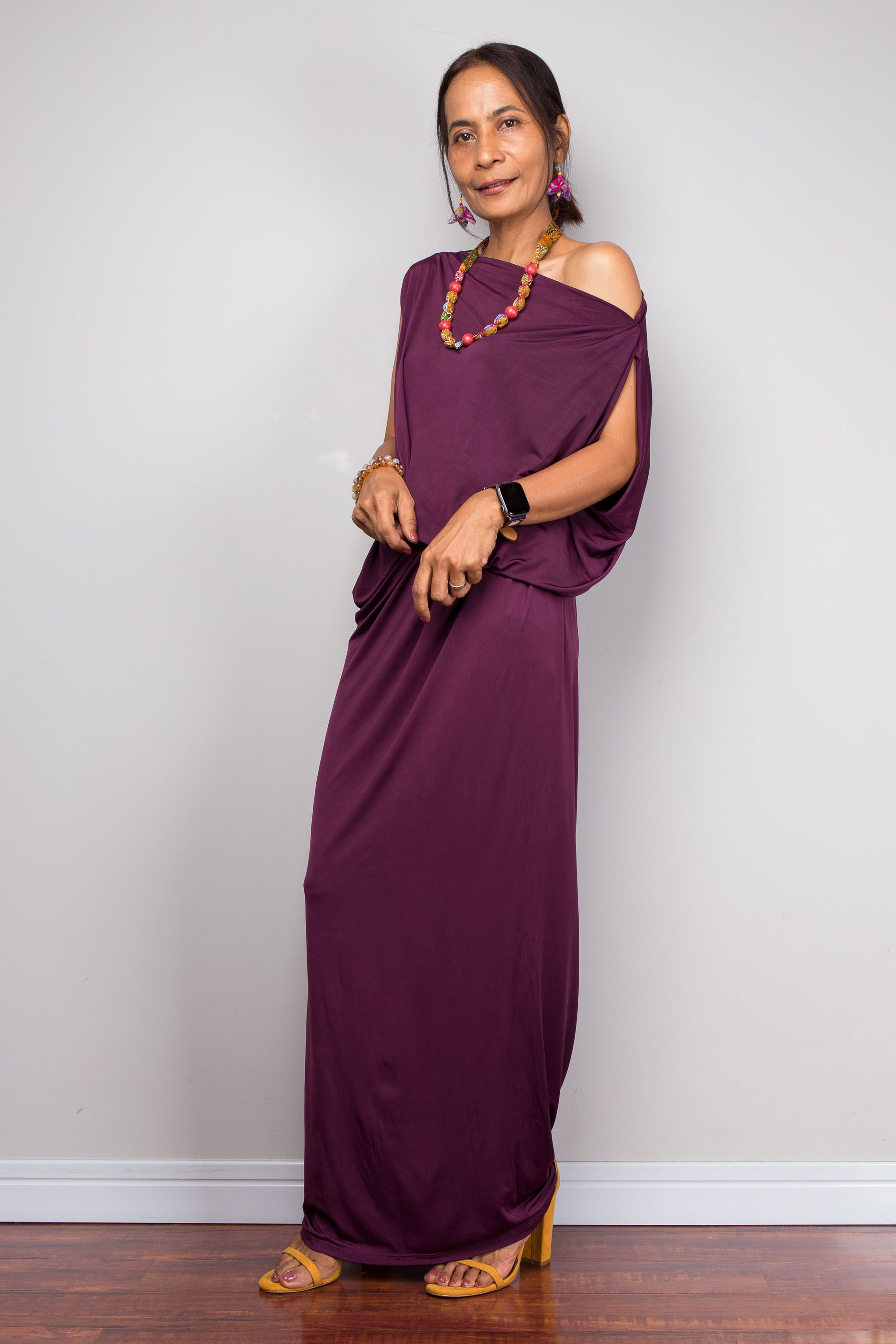 Woman wearing a purple evening dress with a plain background