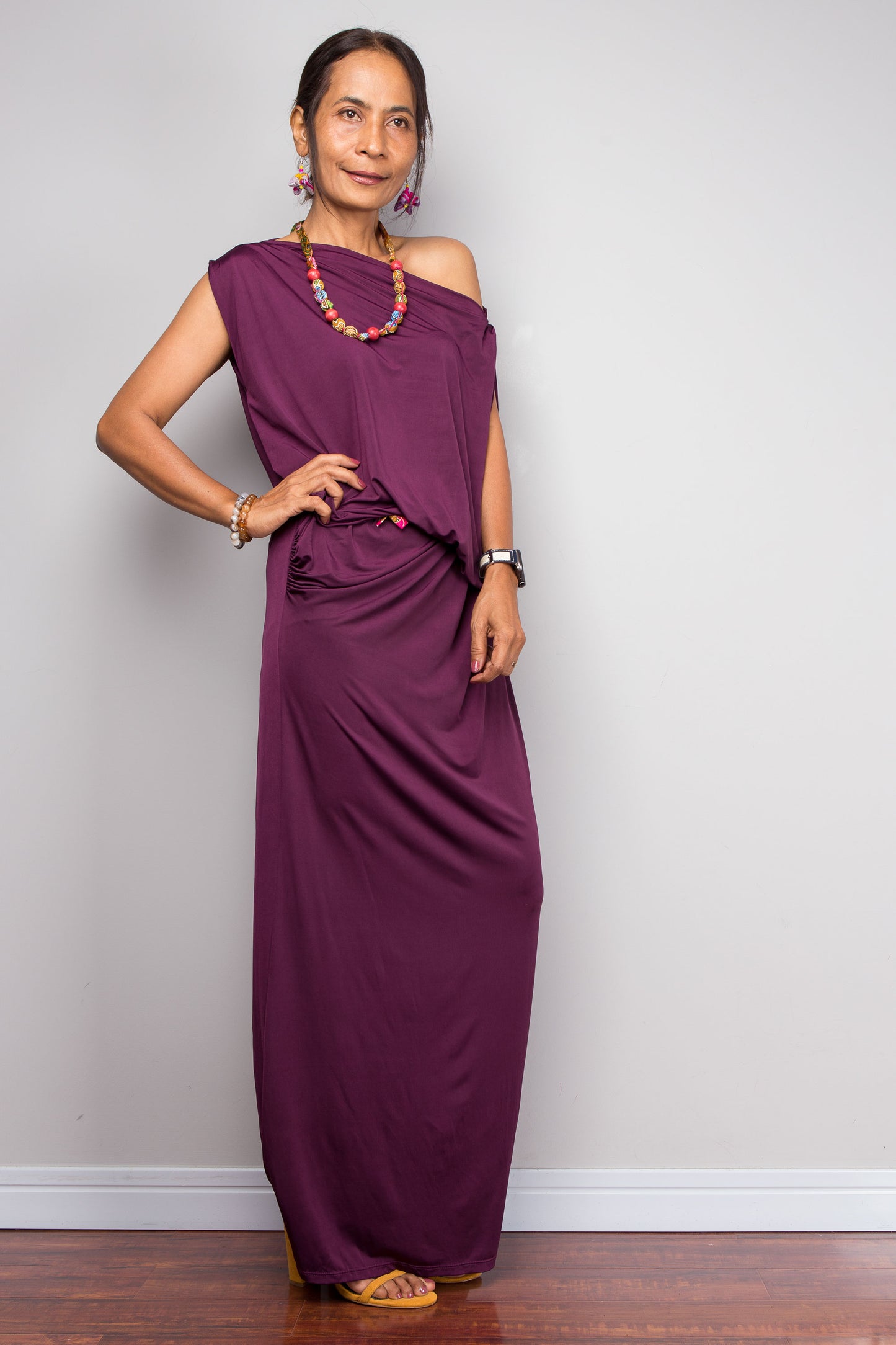Woman wearing a purple dress against a plain background