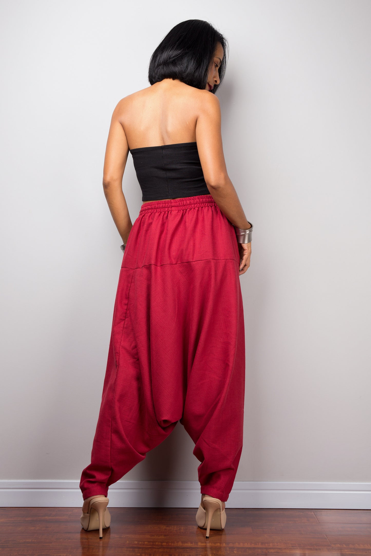 Back view of the model in red harem pants, showing how the pants drape and the fit around the hips.