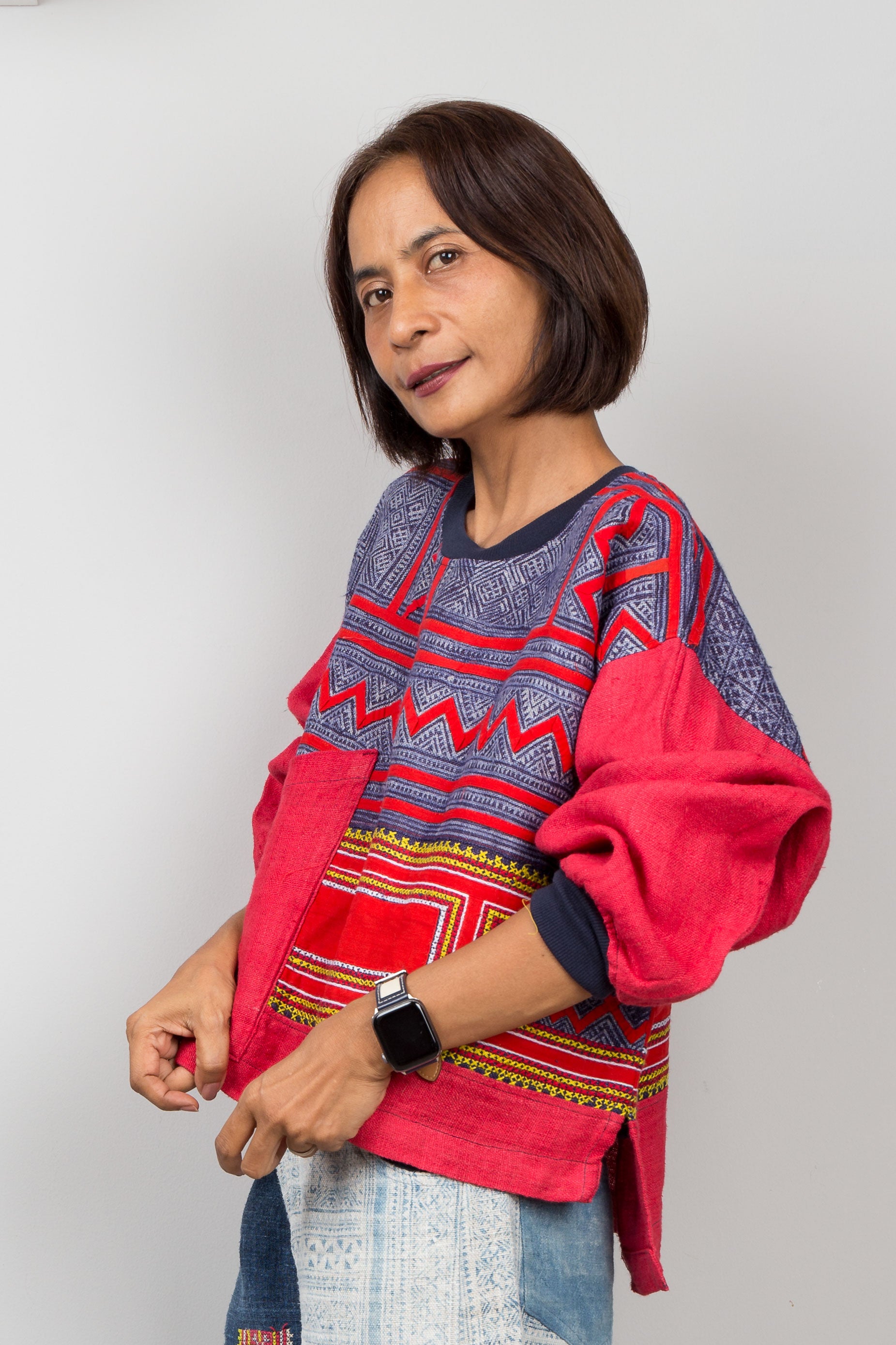 Woman wearing a colorful patterned sweatshirt on a white background