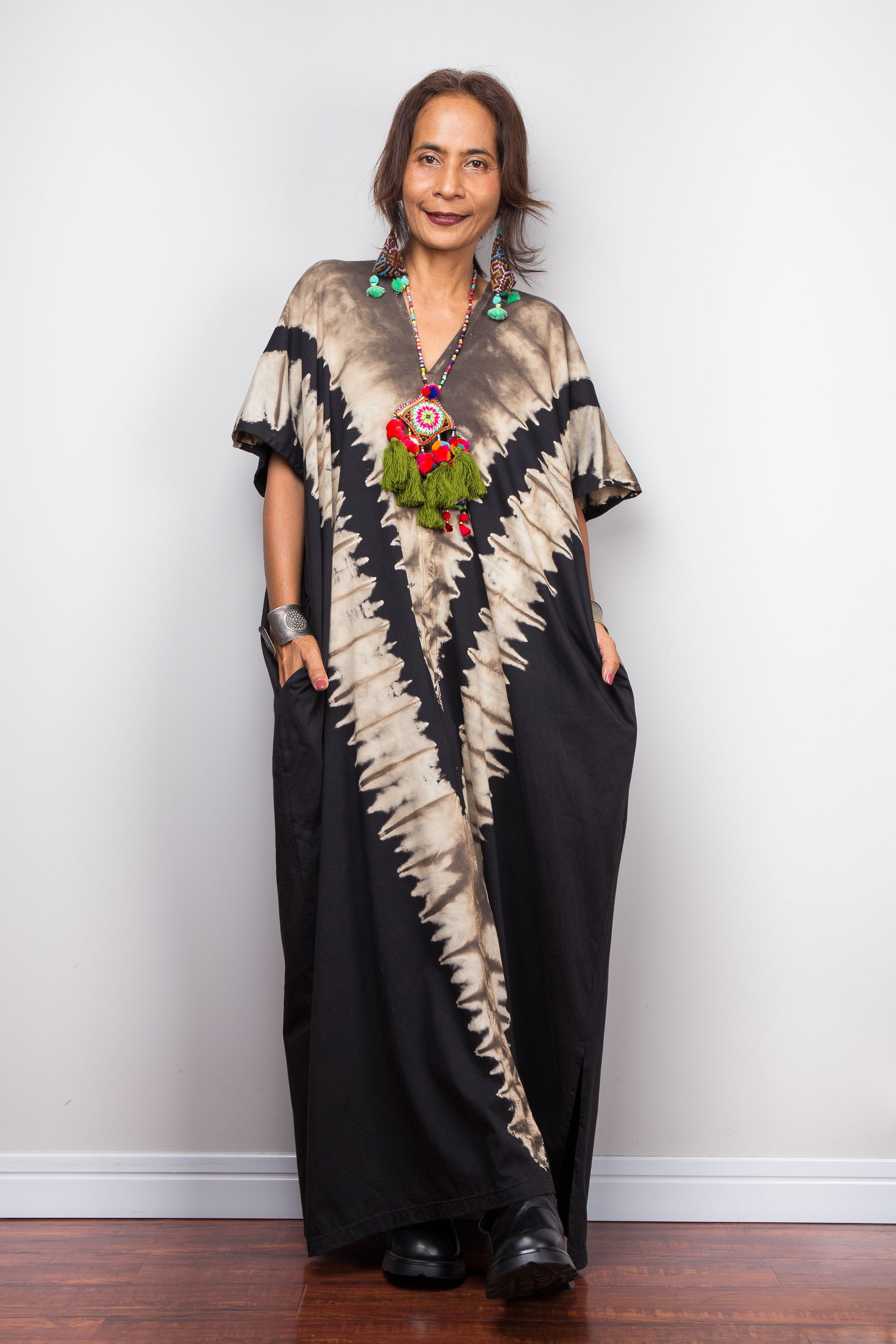 Authentic Nuichan brand oversized black and sand reverse tie dye kaftan dress, a cotton boho maxi dress with short sleeves and pockets worn by a petite model.