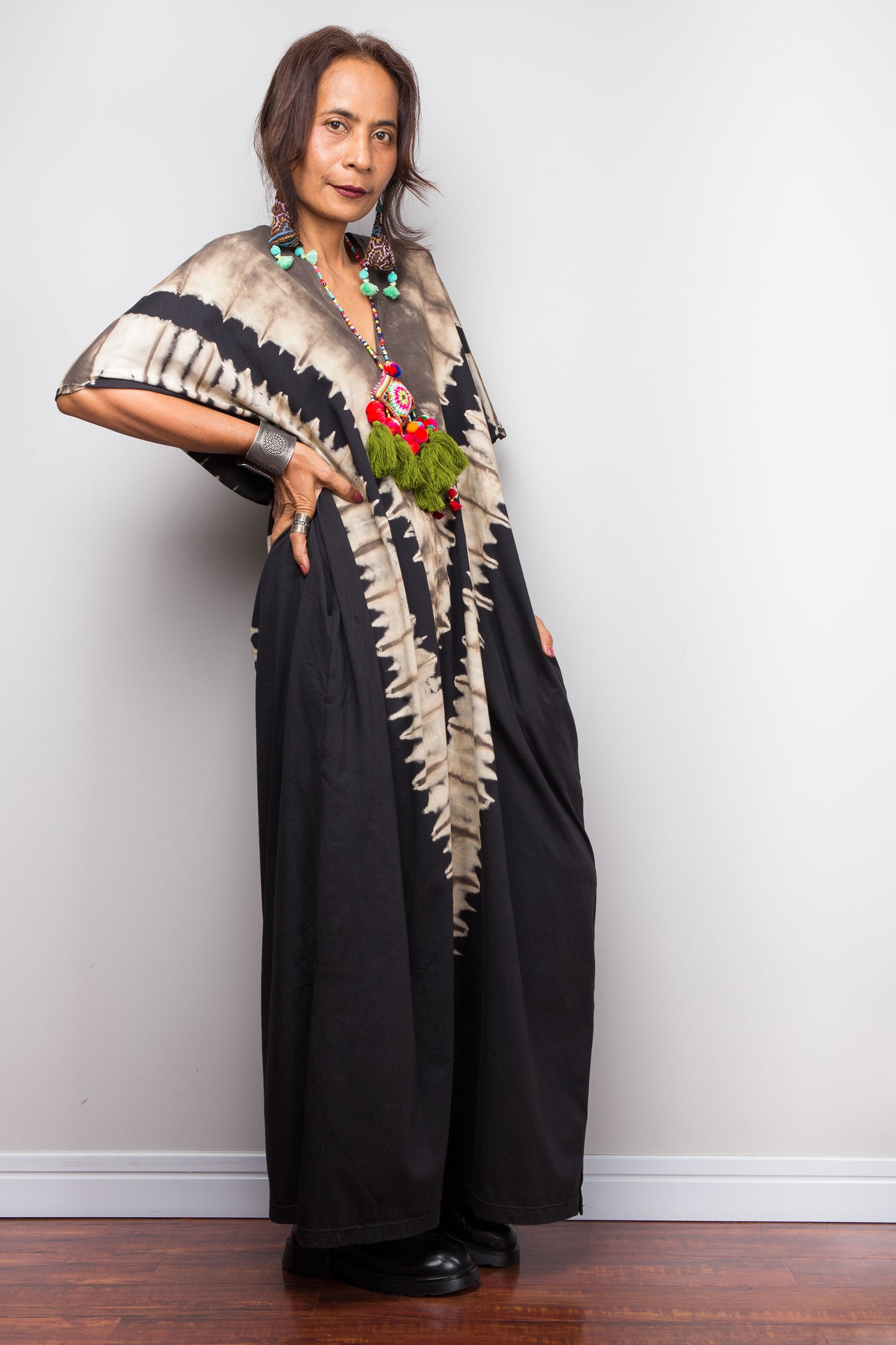 Authentic Nuichan brand oversized black and sand reverse tie dye caftan dress, a cotton boho maxi dress with short sleeves and pockets worn by a petite model.