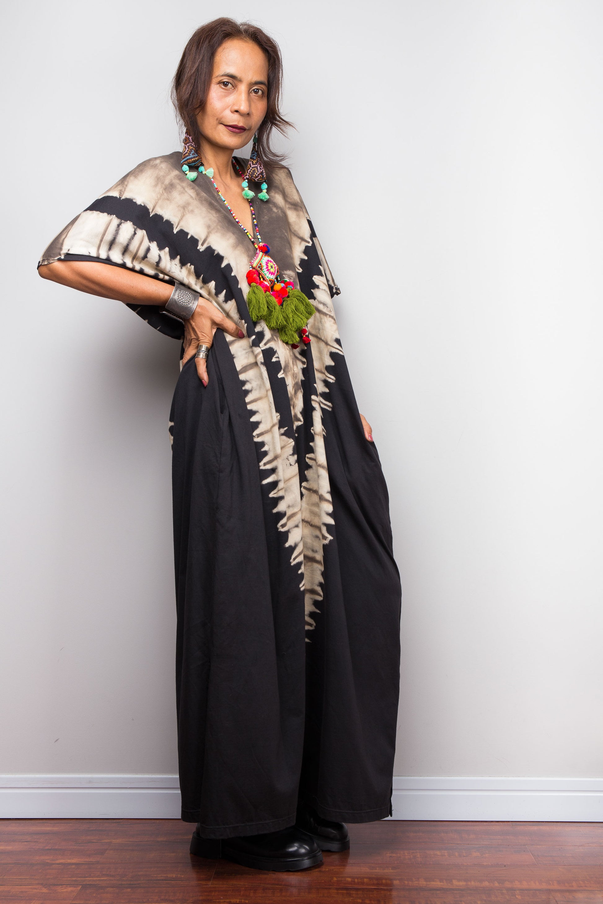 Authentic Nuichan brand oversized black and sand reverse tie dye caftan dress, a cotton boho maxi dress with short sleeves and pockets worn by a petite model.