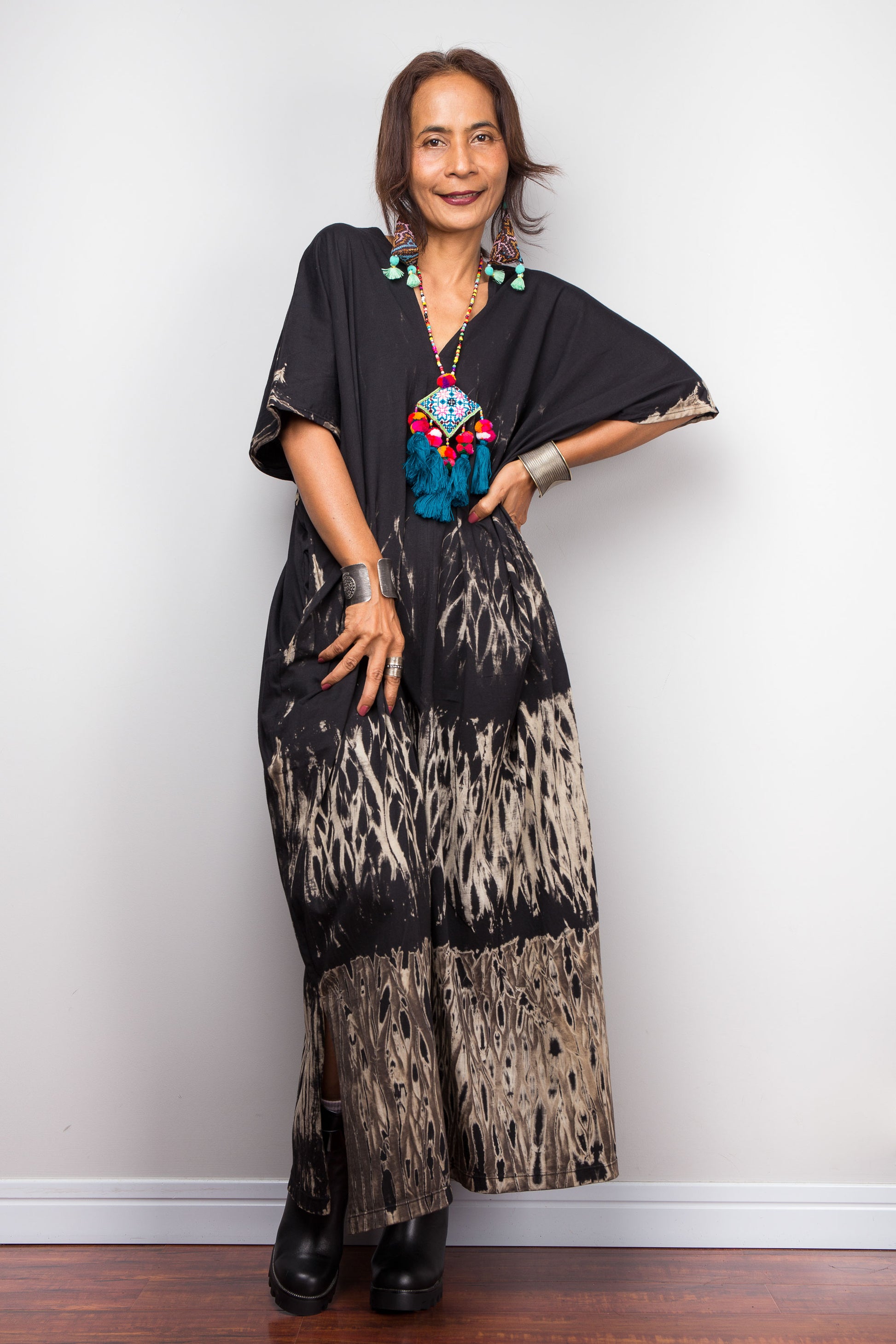 Woman wearing a reverse tie dye kaftan dress with a white background
