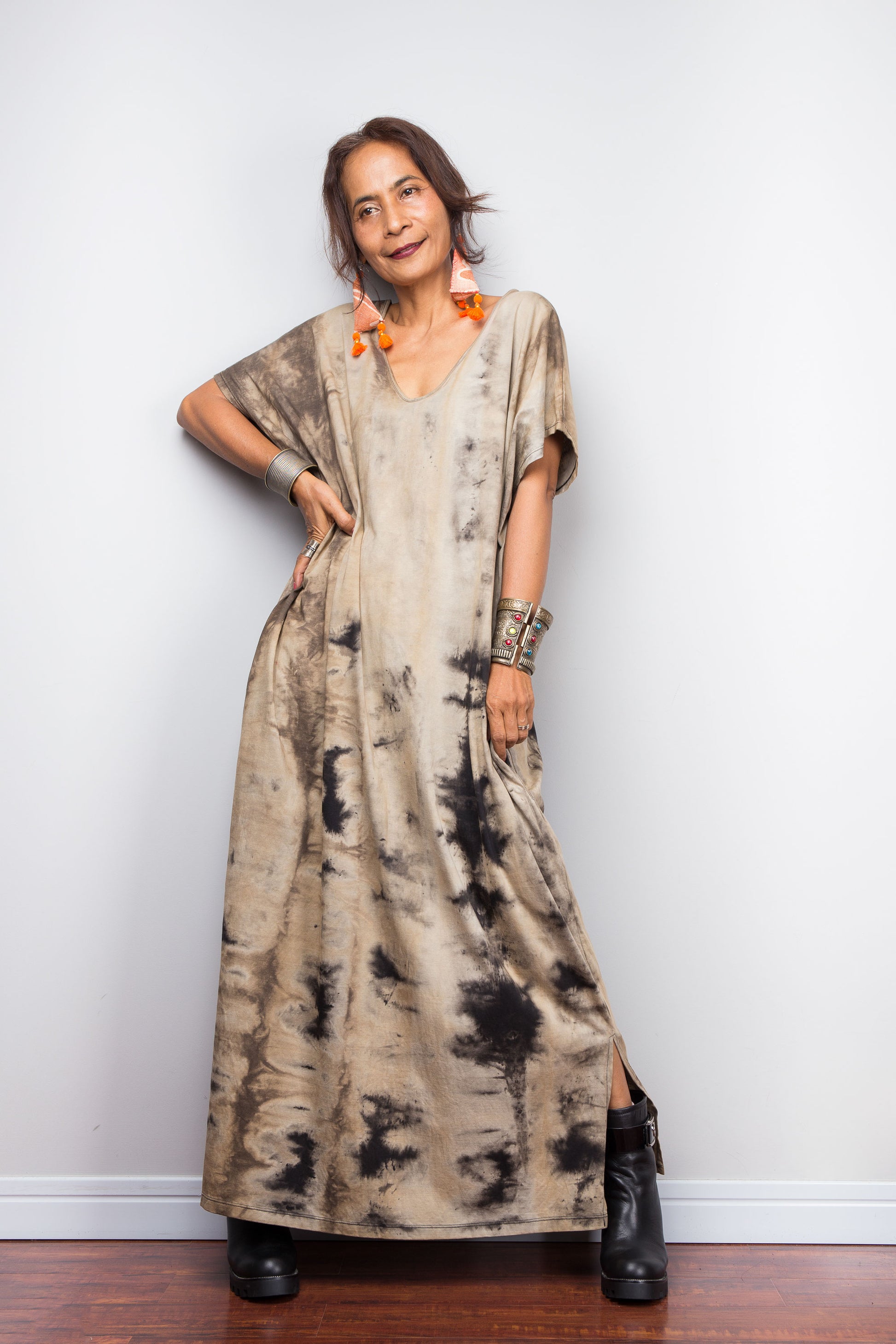 Full front view of a model in an authentic Nuichan brand reverse tie dye dress, featuring a soft sand and beige canvas with dark abstract watercolor bleeding patterns and a V-neckline and split at the hem.