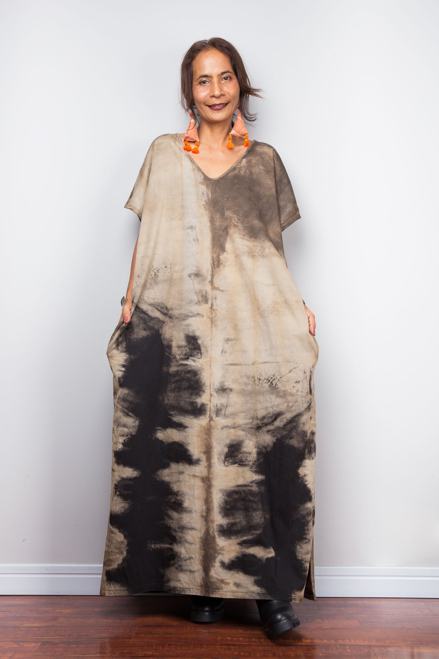 Front view of a petite woman styling Nuichan's oversized reverse tie-dye kaftan dress, showcasing the loose fit and sand-colored pattern.