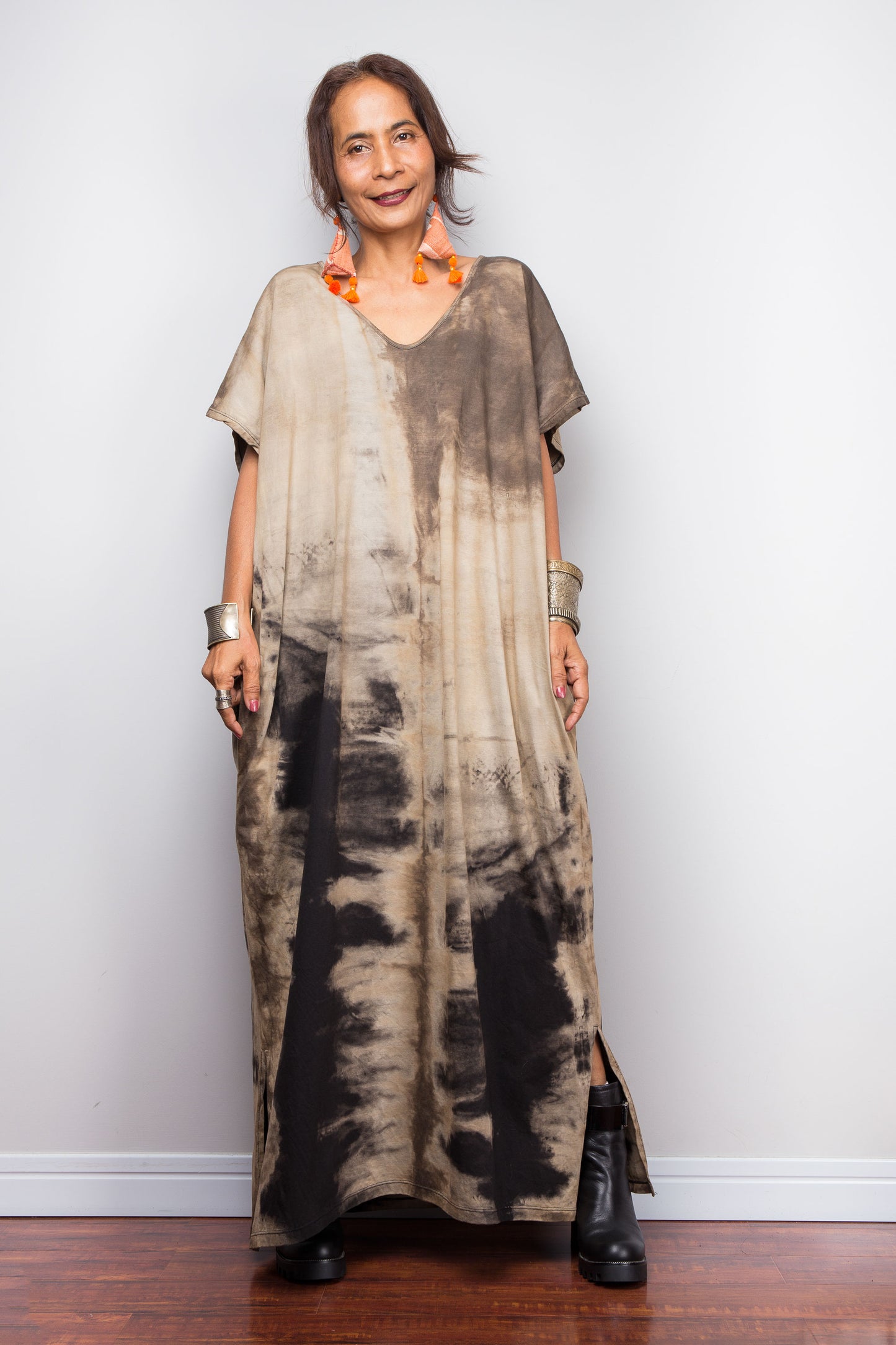 Front view of a petite model styling Nuichan's oversized reverse tie-dye kaftan dress, showcasing the loose fit, split at the hem and sand-colored pattern.