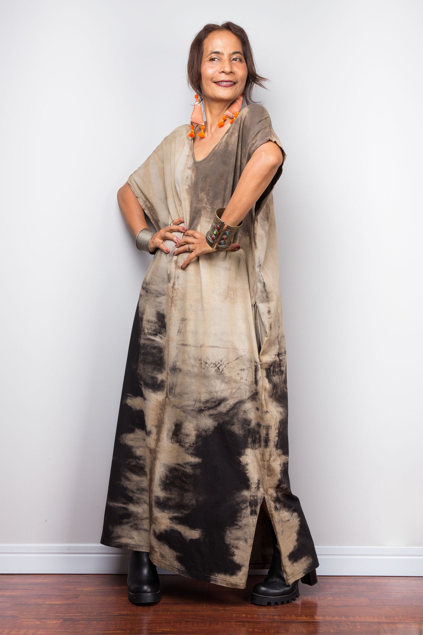 Side view of a model styling Nuichan's oversized reverse tie-dye kaftan dress, showcasing the loose fit and sand-colored pattern.