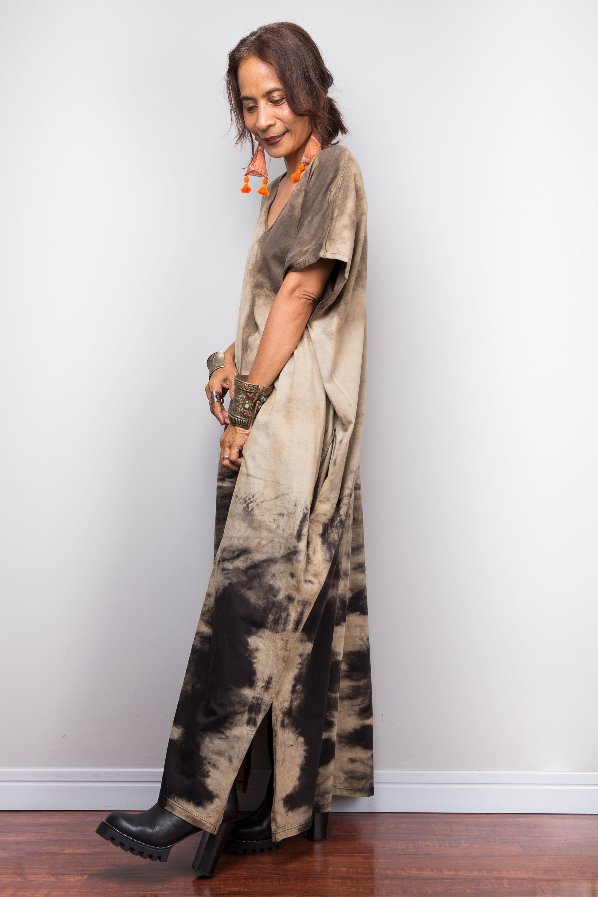 Side view of a petite woman styling Nuichan's oversized reverse tie-dye kaftan dress, showcasing the loose fit and sand-colored pattern.