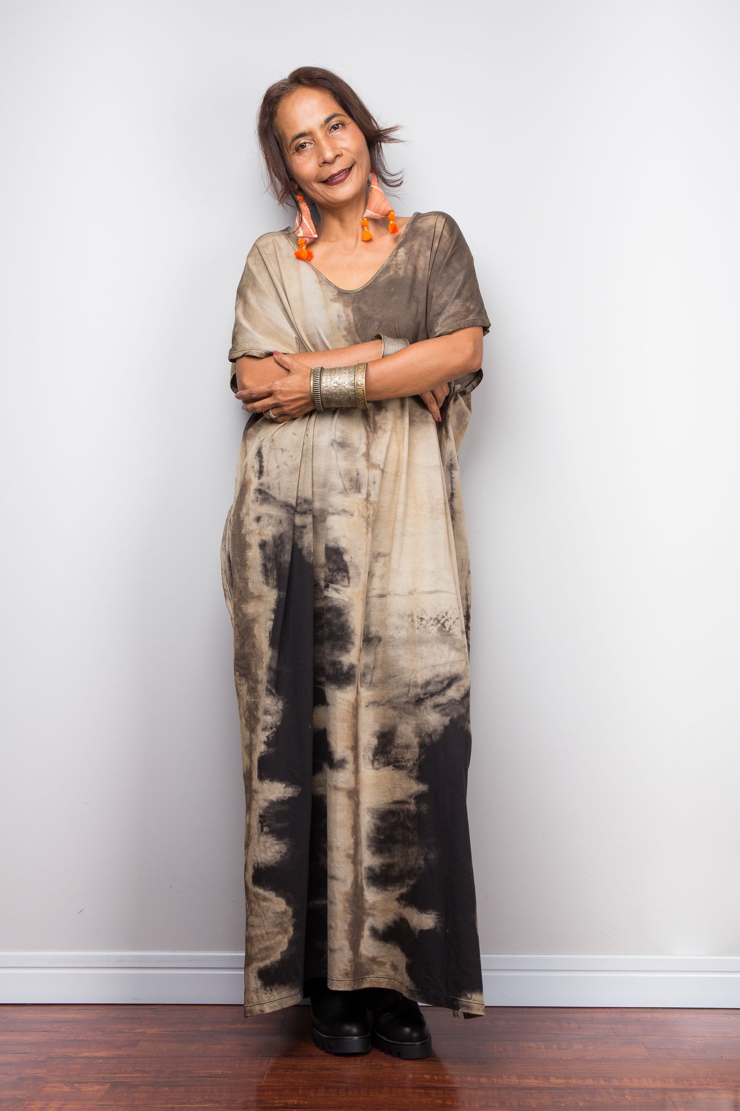 Front view of a female petite model styling Nuichan's oversized reverse tie-dye kaftan dress, showcasing the loose fit and sand-colored pattern.