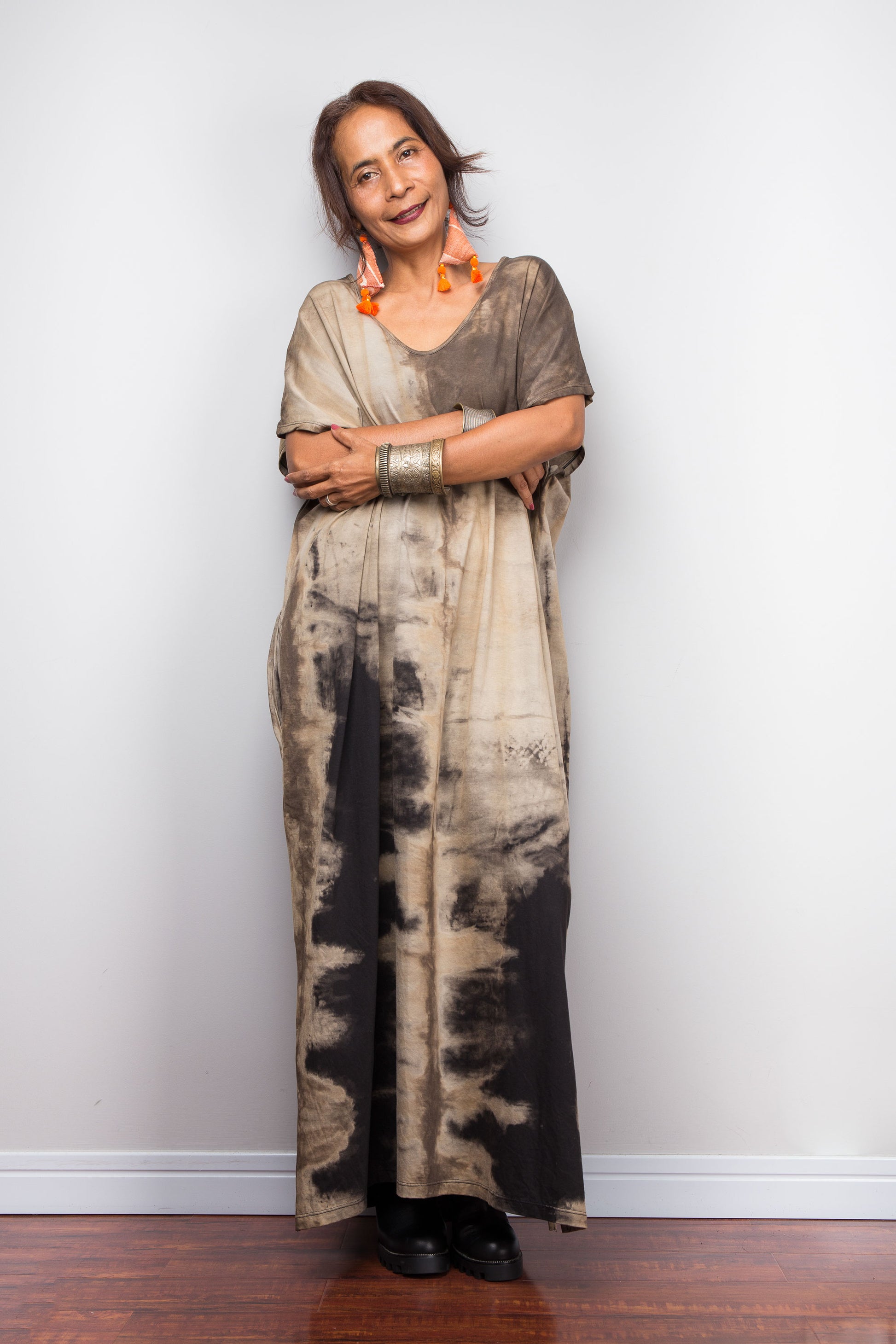 Front view of a female petite model styling Nuichan's oversized reverse tie-dye kaftan dress, showcasing the loose fit and sand-colored pattern.