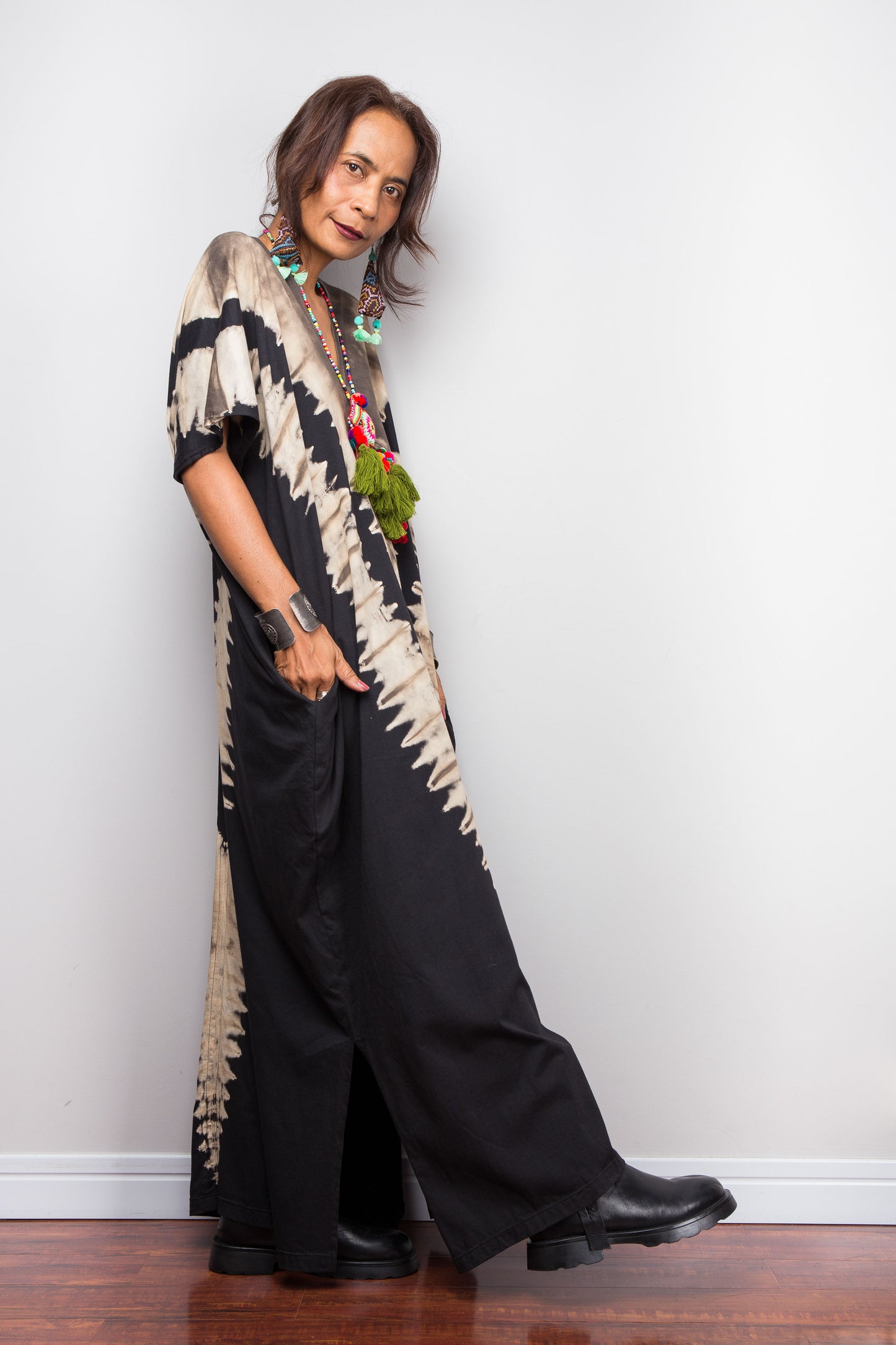 Unique Nuichan brand oversized black and sand reverse tie dye kaftan dress, a cotton boho maxi dress with short sleeves and pockets worn by a petite model.