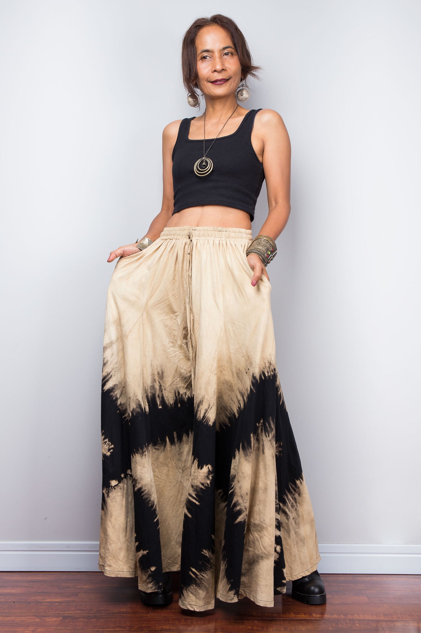 Side view of the Nuichan black and sand bleach dye lounge pants, showcasing the model utilizing the functional, deep integrated side pockets without disrupting the fluid drape of the cotton.