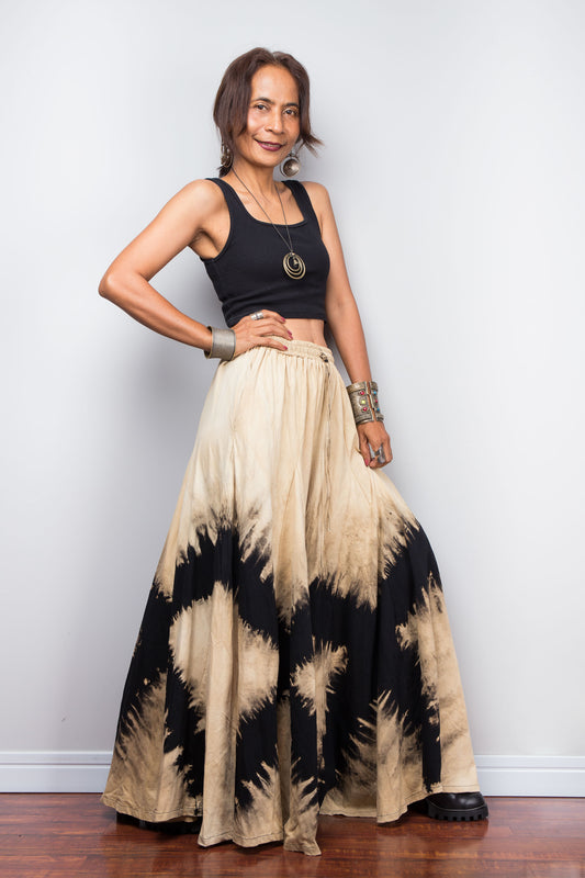 Model posing dynamically to showcase the immense fabric volume of Nuichan's oversized reverse tie dye palazzo pants, illustrating the skirt-like flow and dramatic movement of the unstructured wide legs.