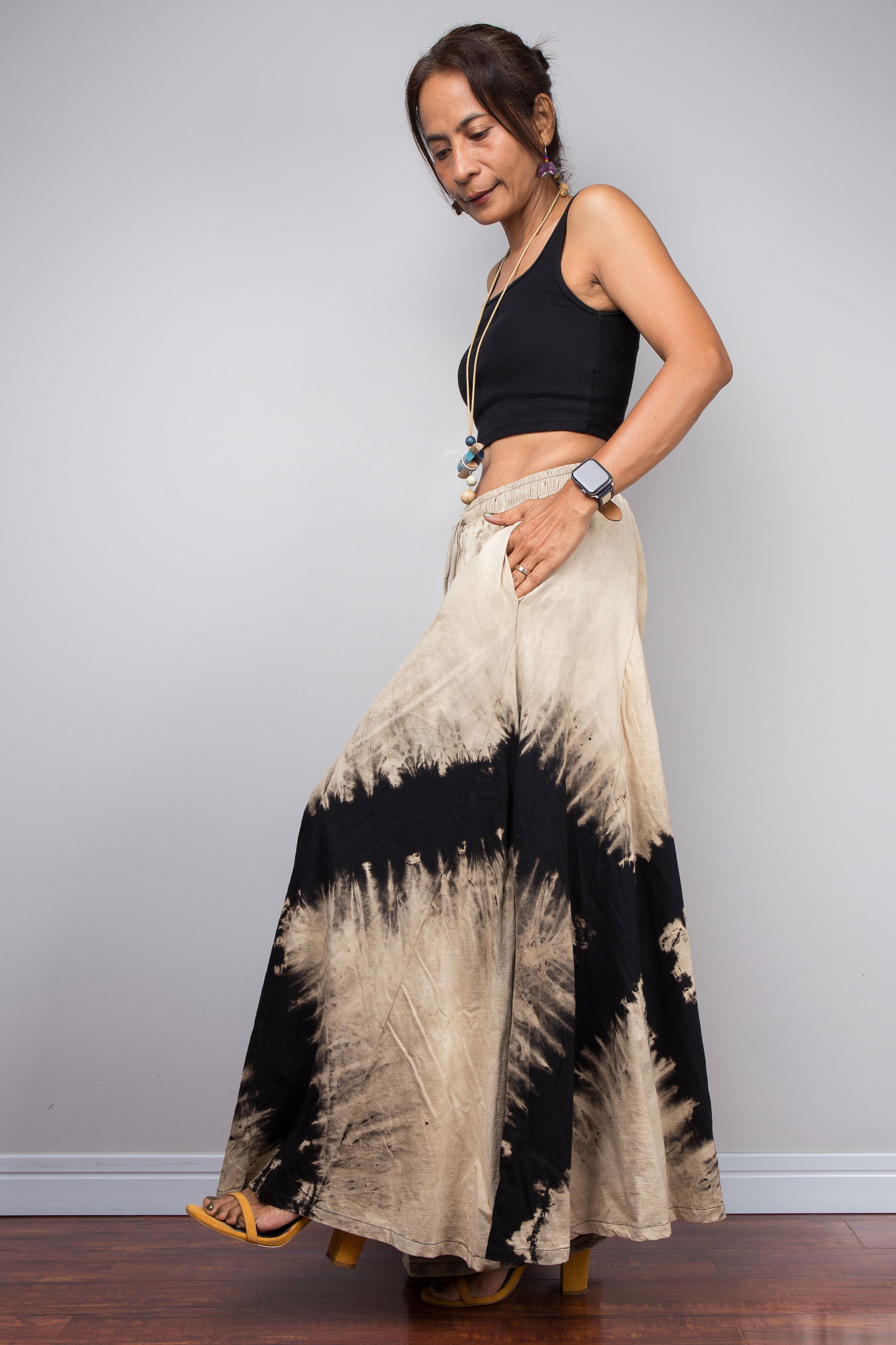 Side view of the Nuichan black and sand bleach dye lounge pants, showcasing the model utilizing the functional, deep integrated side pockets without disrupting the fluid drape of the cotton.