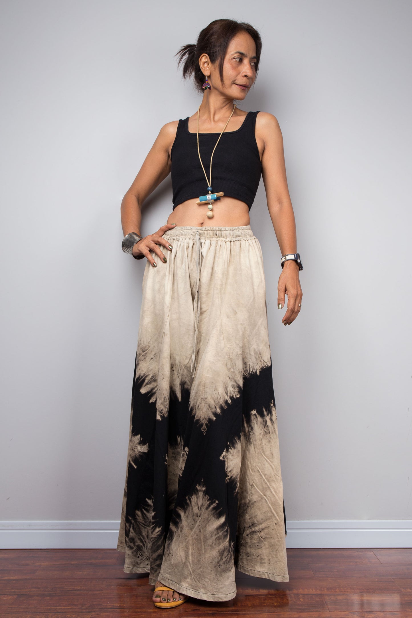 Front Side view of the Nuichan black and sand bleach dye lounge pants, showcasing the model utilizing the functional, deep integrated side pockets without disrupting the fluid drape of the cotton.