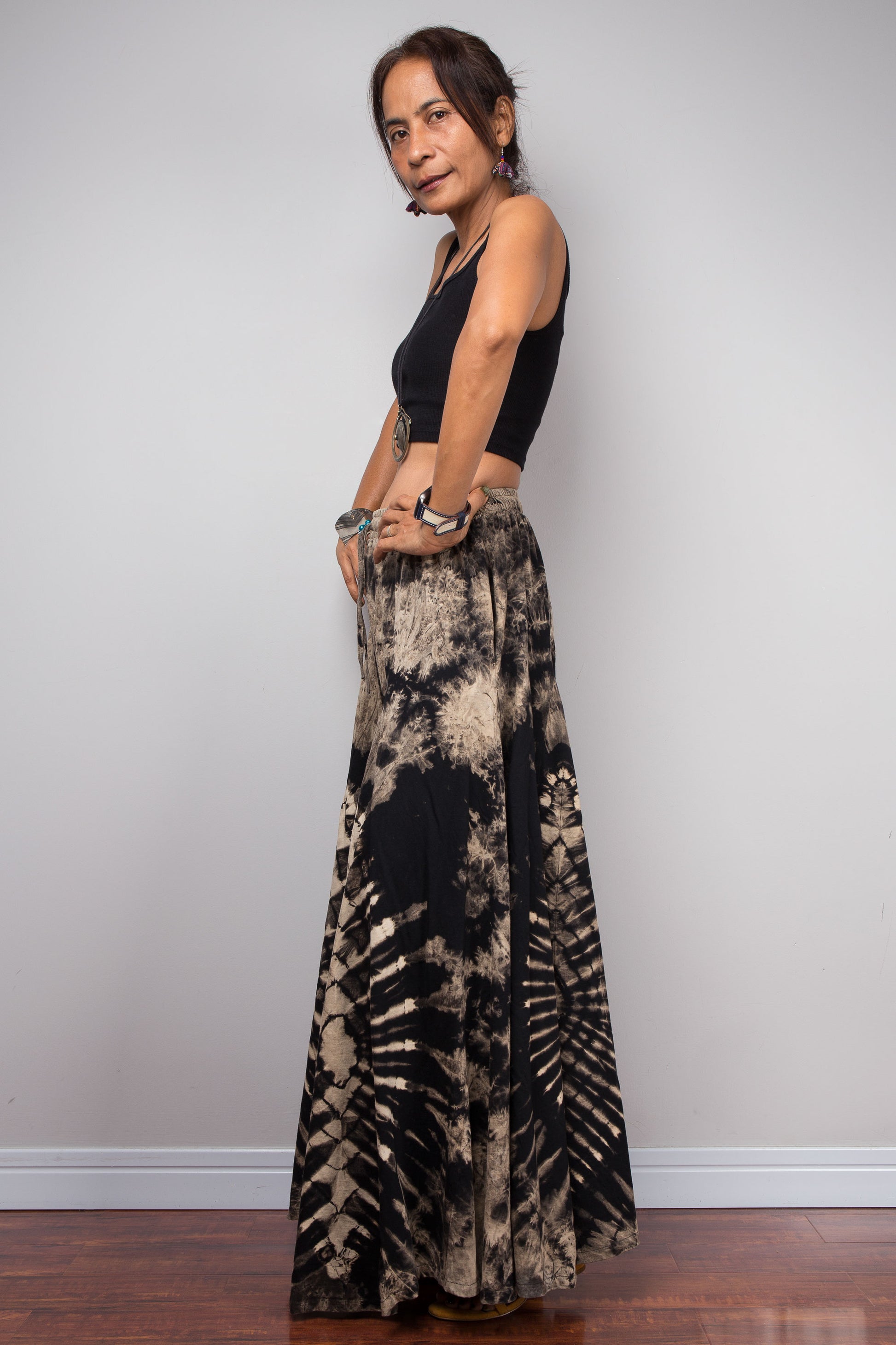 Full-length side view of a model wearing the Nuichan handmade reverse dye wide leg pants, illustrating how the dramatic ultra-wide cotton legs mimic the elegant sweeping flow of a maxi skirt in motion