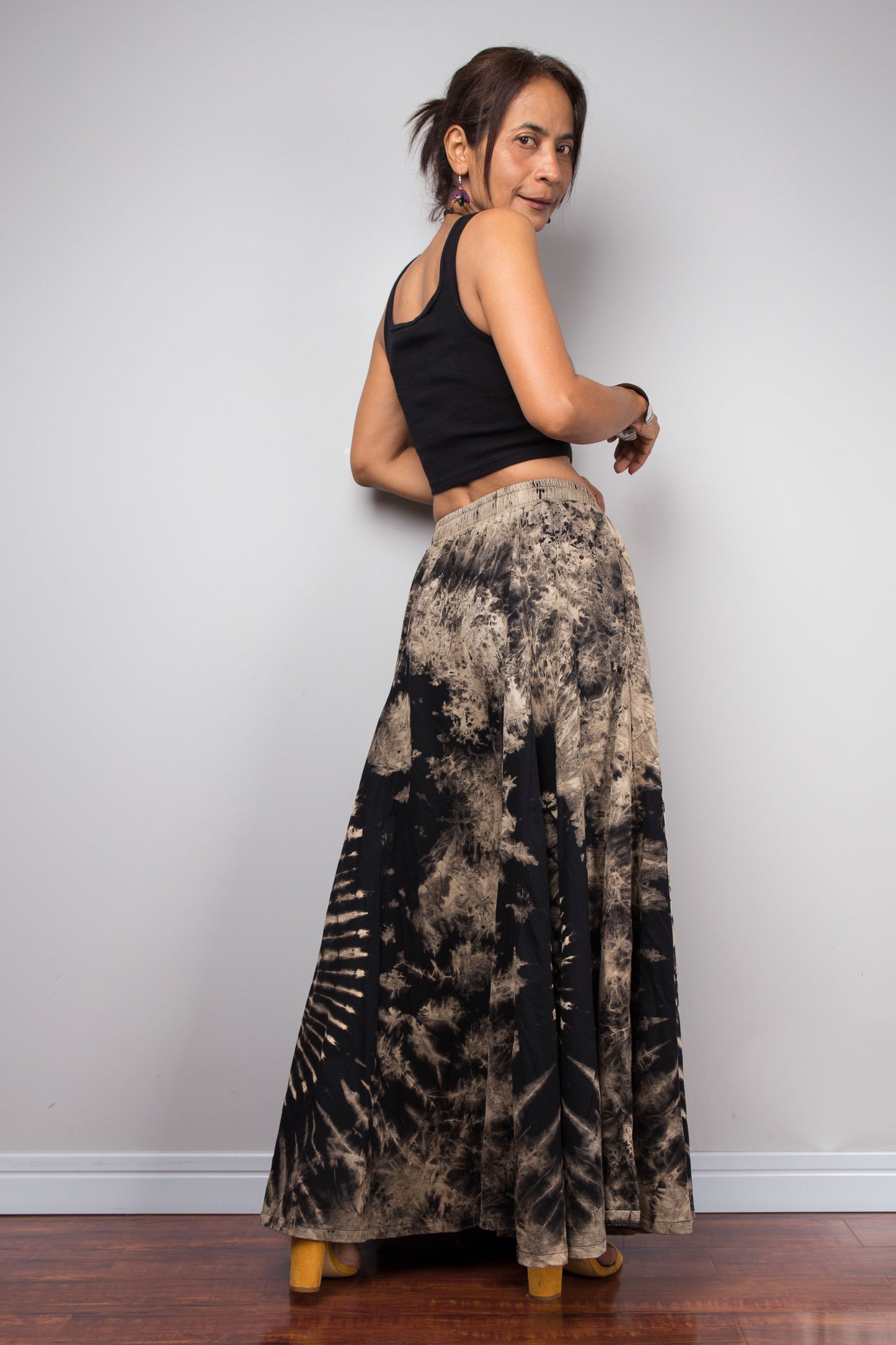 Full-length rear view of a model wearing the Nuichan handmade reverse dye wide leg pants, illustrating how the dramatic ultra-wide cotton legs mimic the elegant sweeping flow of a maxi skirt in motion
