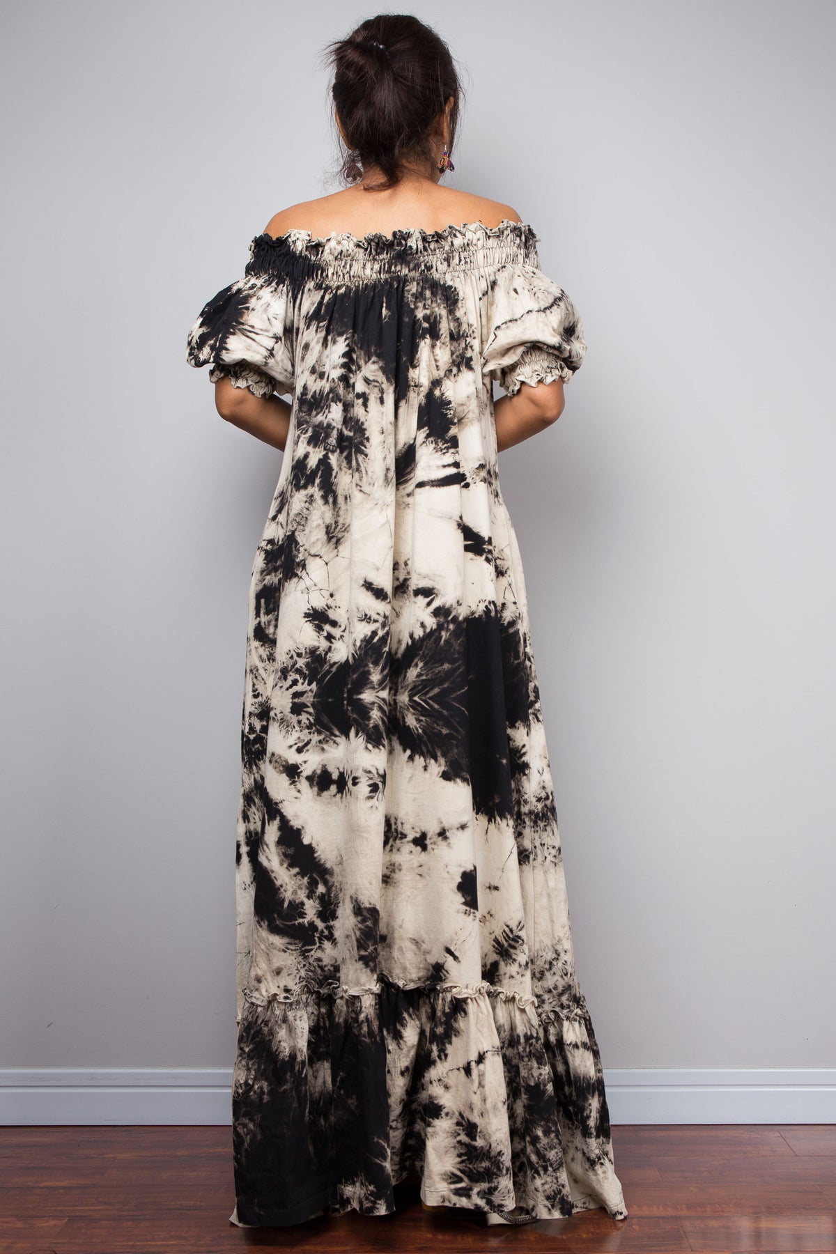 Full-length rear view of a petite model in the Nuichan reverse tie dye off-shoulder button-down maxi dress, showcasing the complete silhouette from elasticated smocked neckline to tiered ruffle hem with deep side pockets