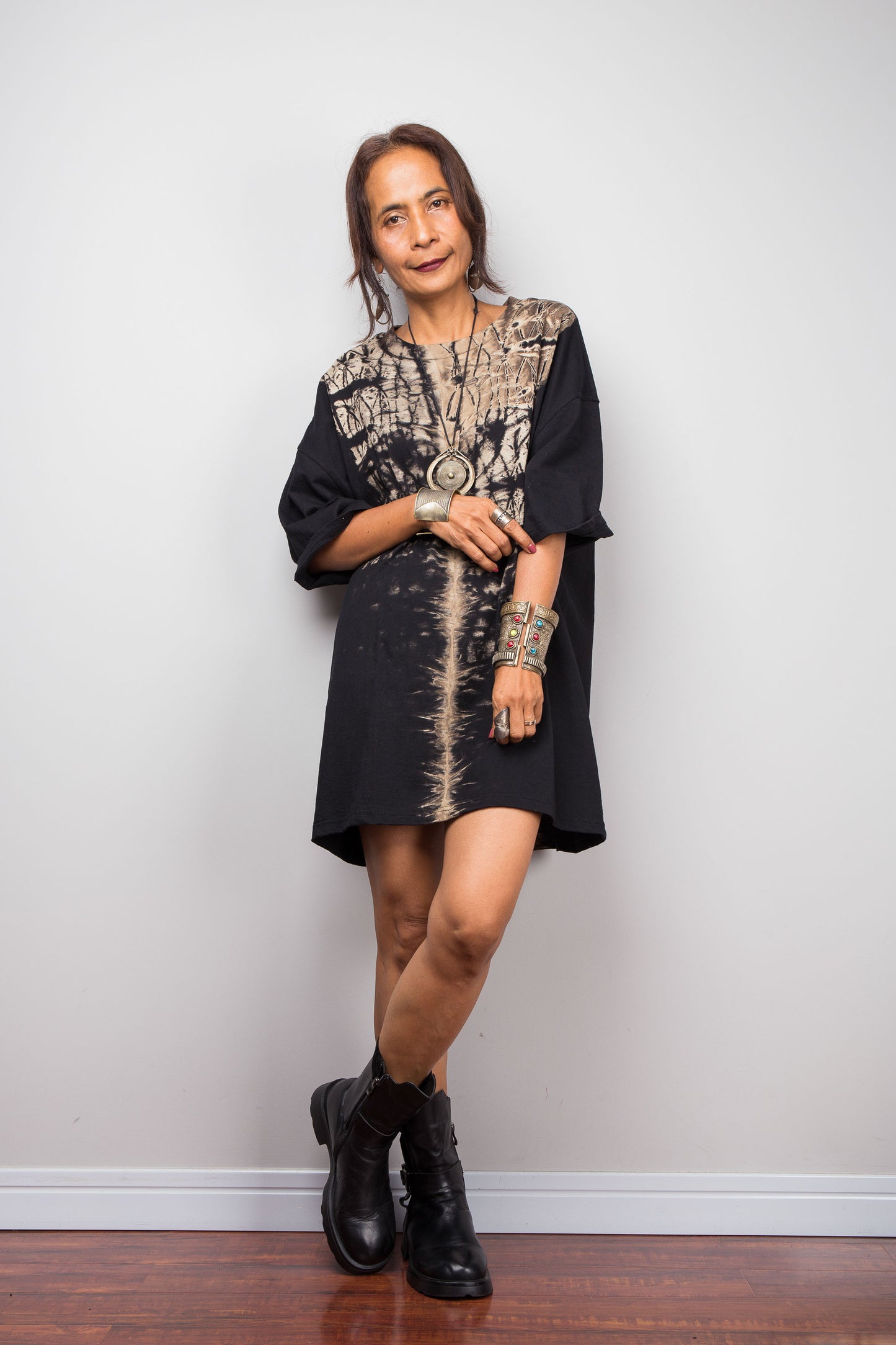 Front view of a petite woman styling Nuichan's oversized reverse tie-dye t-shirt dress, showcasing the loose boxy fit and vertical sand-colored starburst pattern