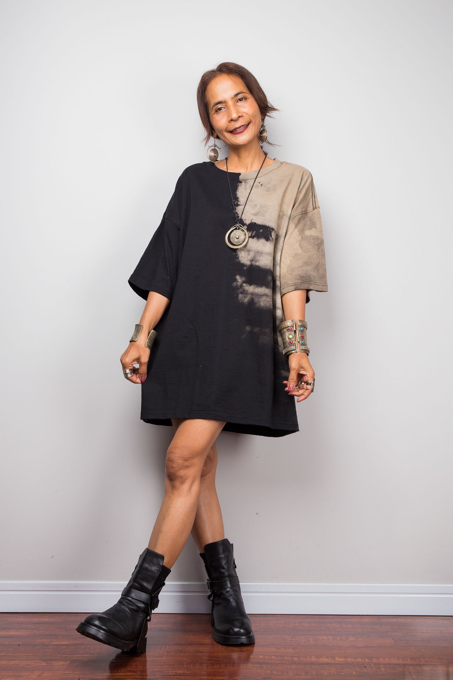Front view of a female model styling Nuichan's oversized reverse tie-dye tee with black boots, showcasing the loose boxy fit and sand-colored pattern