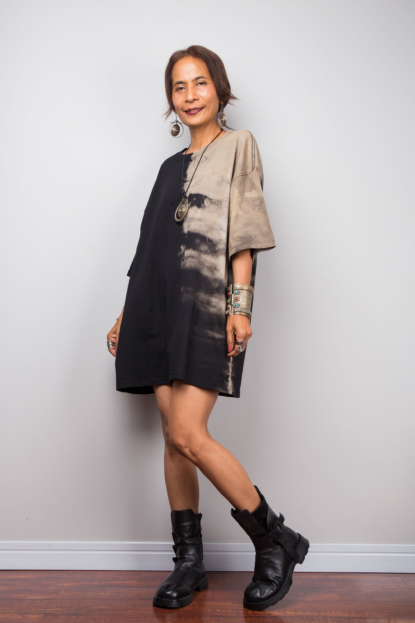Front Side view of a model styling Nuichan's oversized reverse tie-dye tee with black boots, showcasing the loose boxy fit and sand-colored pattern