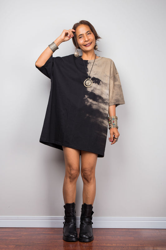 Front view of a model styling Nuichan's oversized reverse tie-dye tee with black boots, showcasing the loose boxy fit and sand-colored pattern