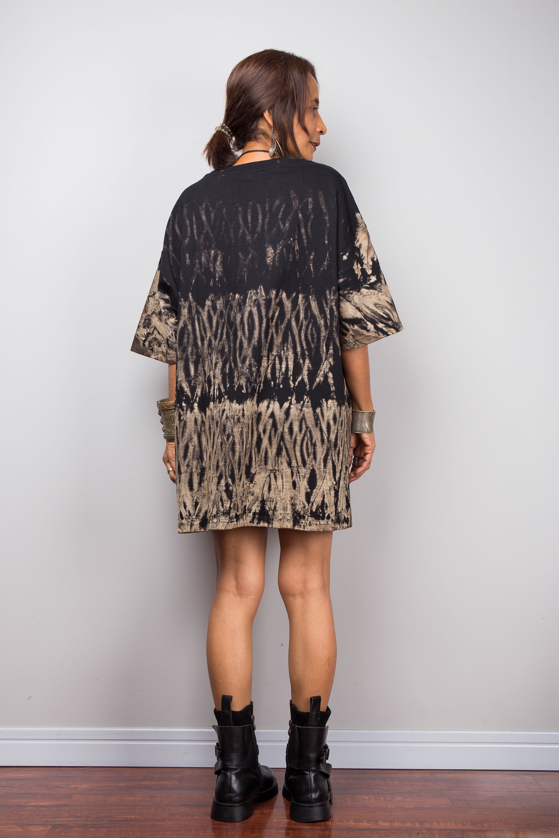 Back view of a model styling Nuichan's oversized reverse tie-dye t-shirt, showcasing the loose boxy fit and black with sand-colored pattern.
