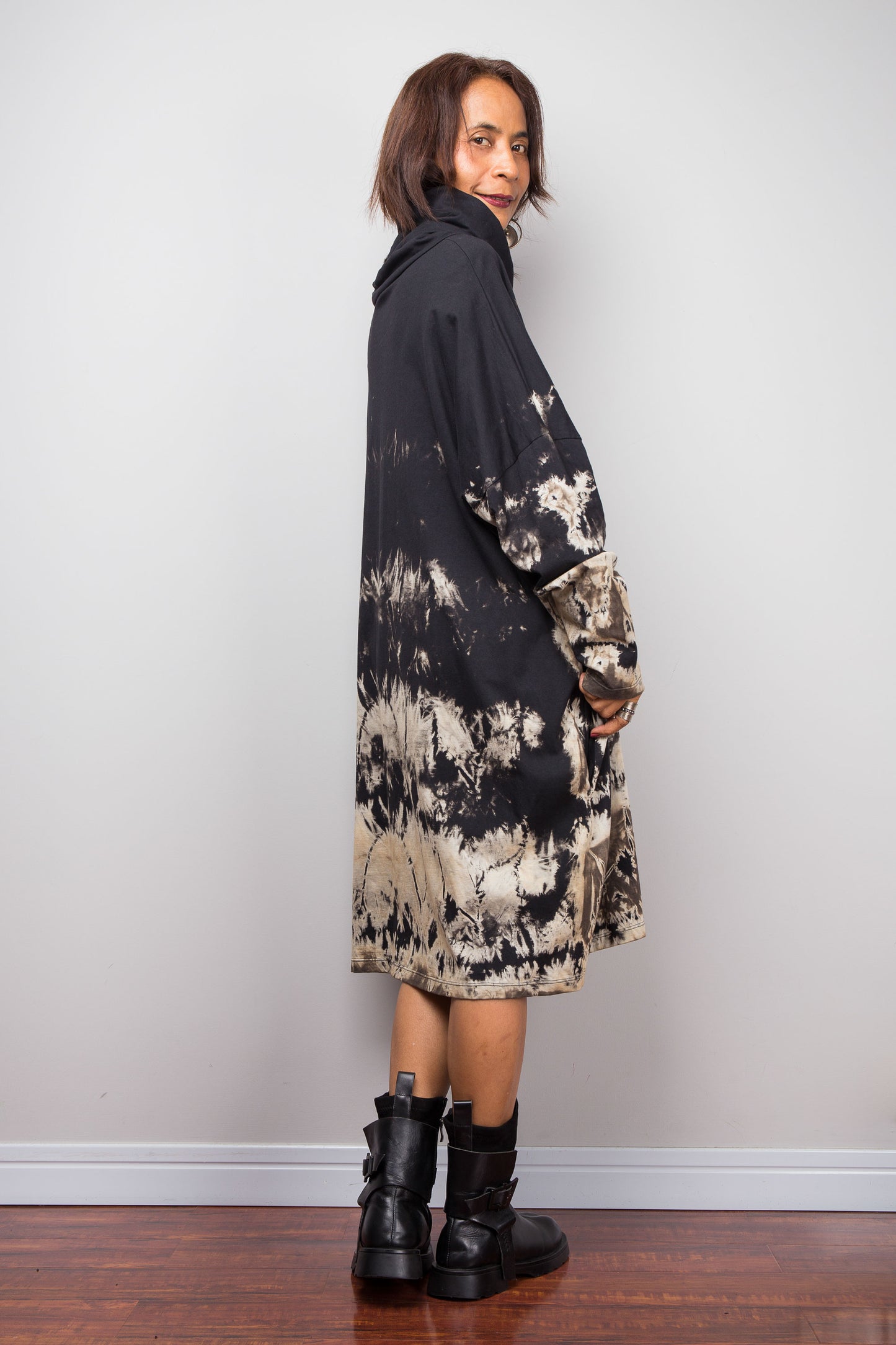 Petite women wearing an Oversized Nuichan reverse tie-dye tunic dress featuring a funnel cowl neck and abstract sand and black patterns.  Back view 