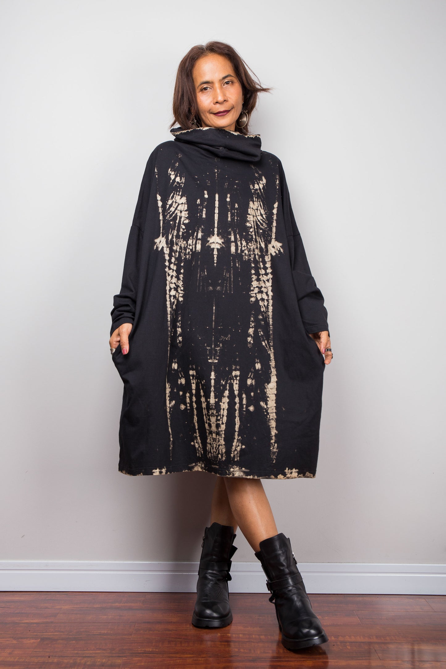 Oversized Nuichan reverse tie dye tunic dress featuring a cowl neck and vertical abstract sand and black patterns. Front view showing two side pockets and long sleeves.